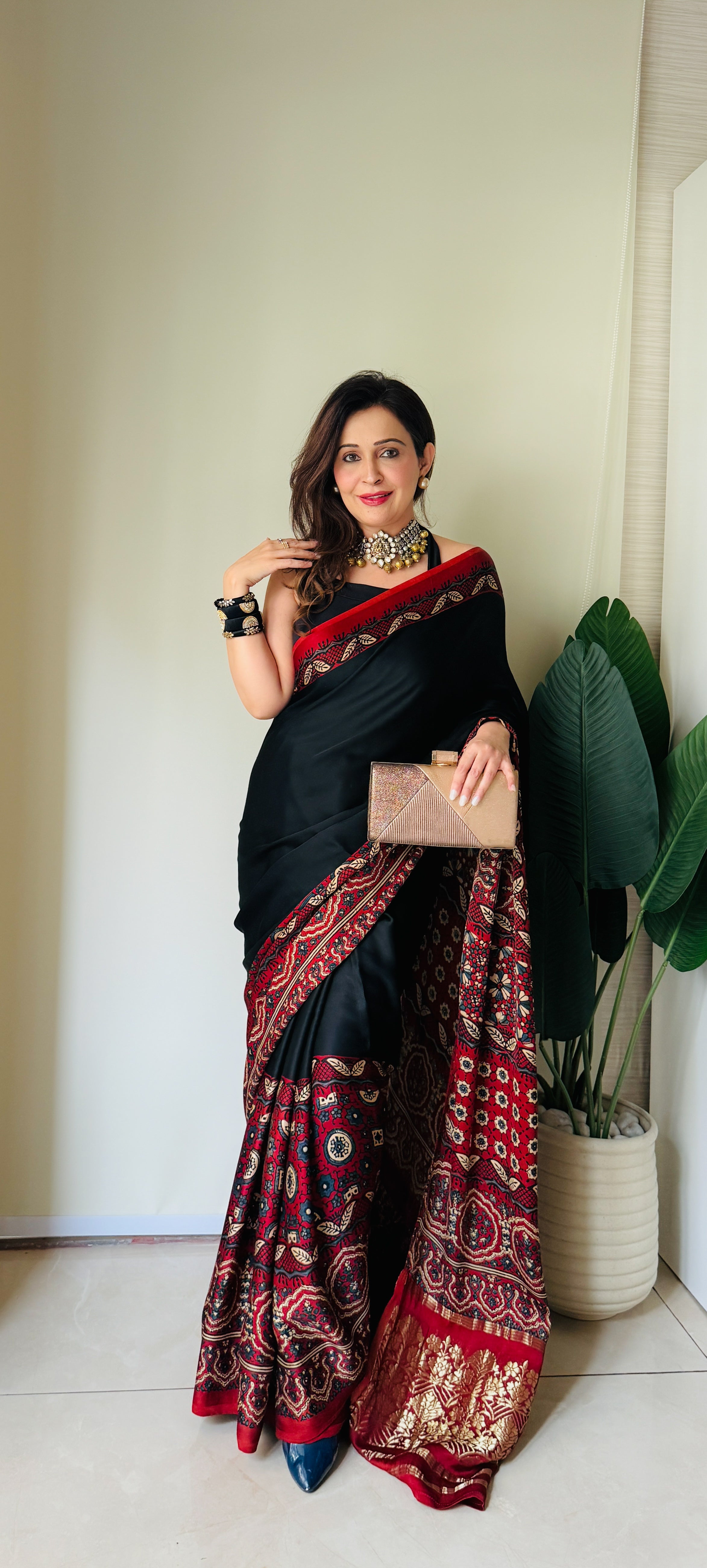 Woman wearing a black and red ajrakh saree from Kawaii with traditional patterns and gold accents