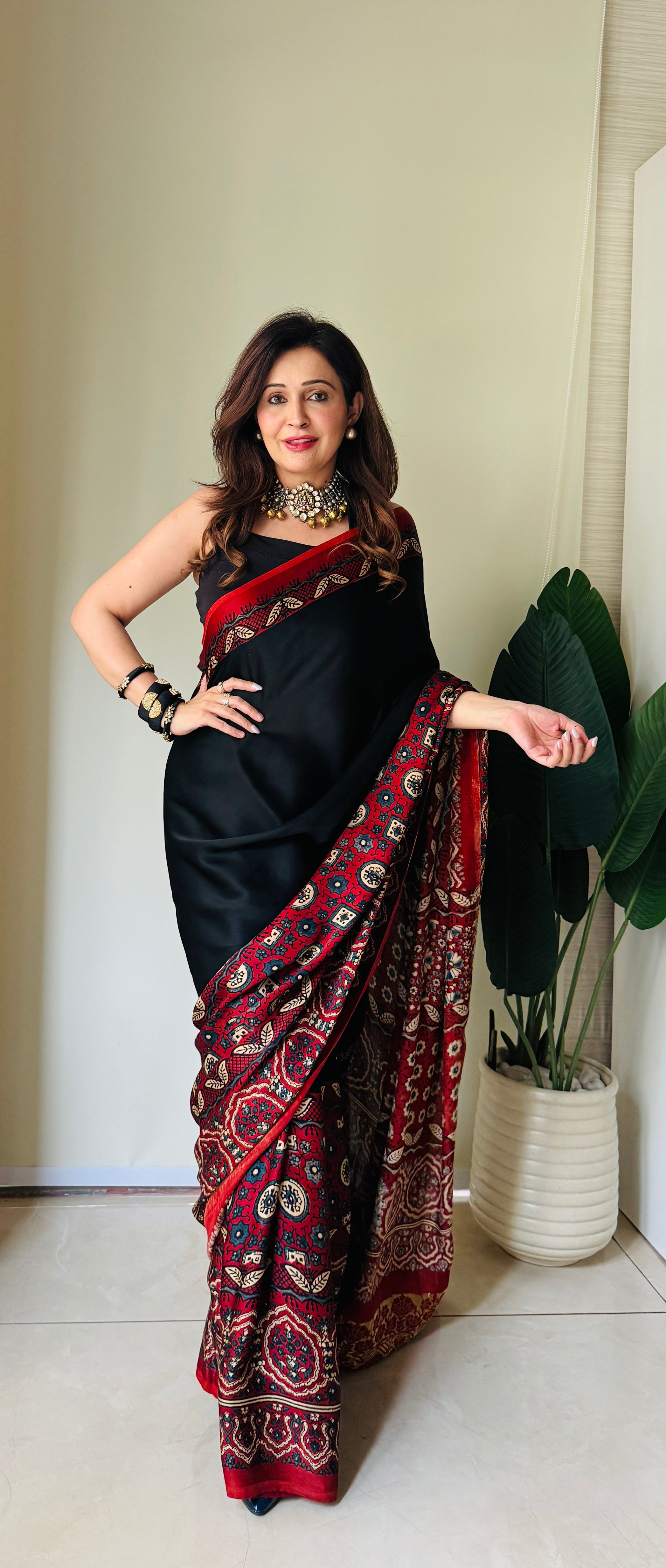 Woman wearing black and red printed ajrakh saree with traditional jewelry by Kawaii