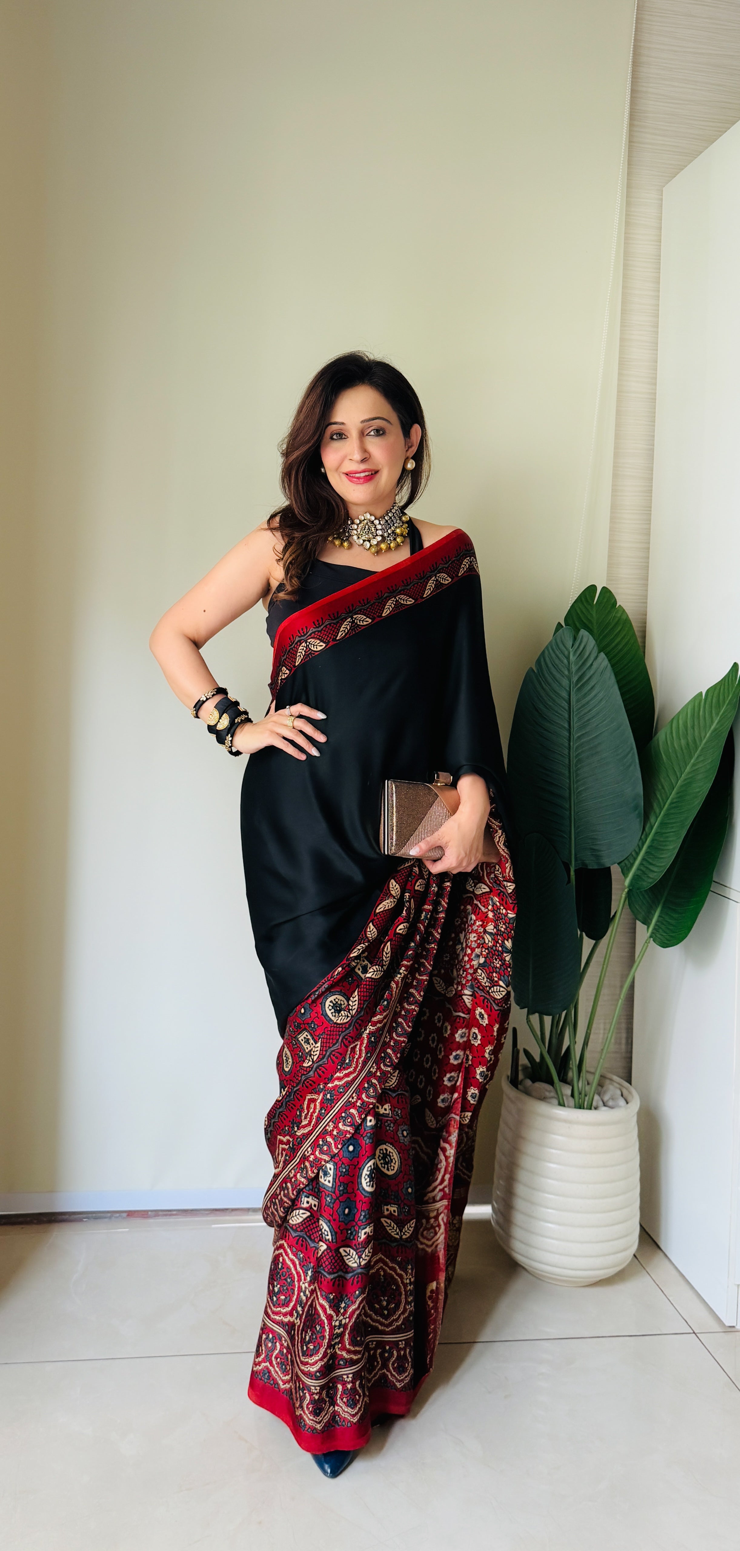 Woman wearing Kawaii ajrakh saree in black and red with traditional patterns and elegant jewelry