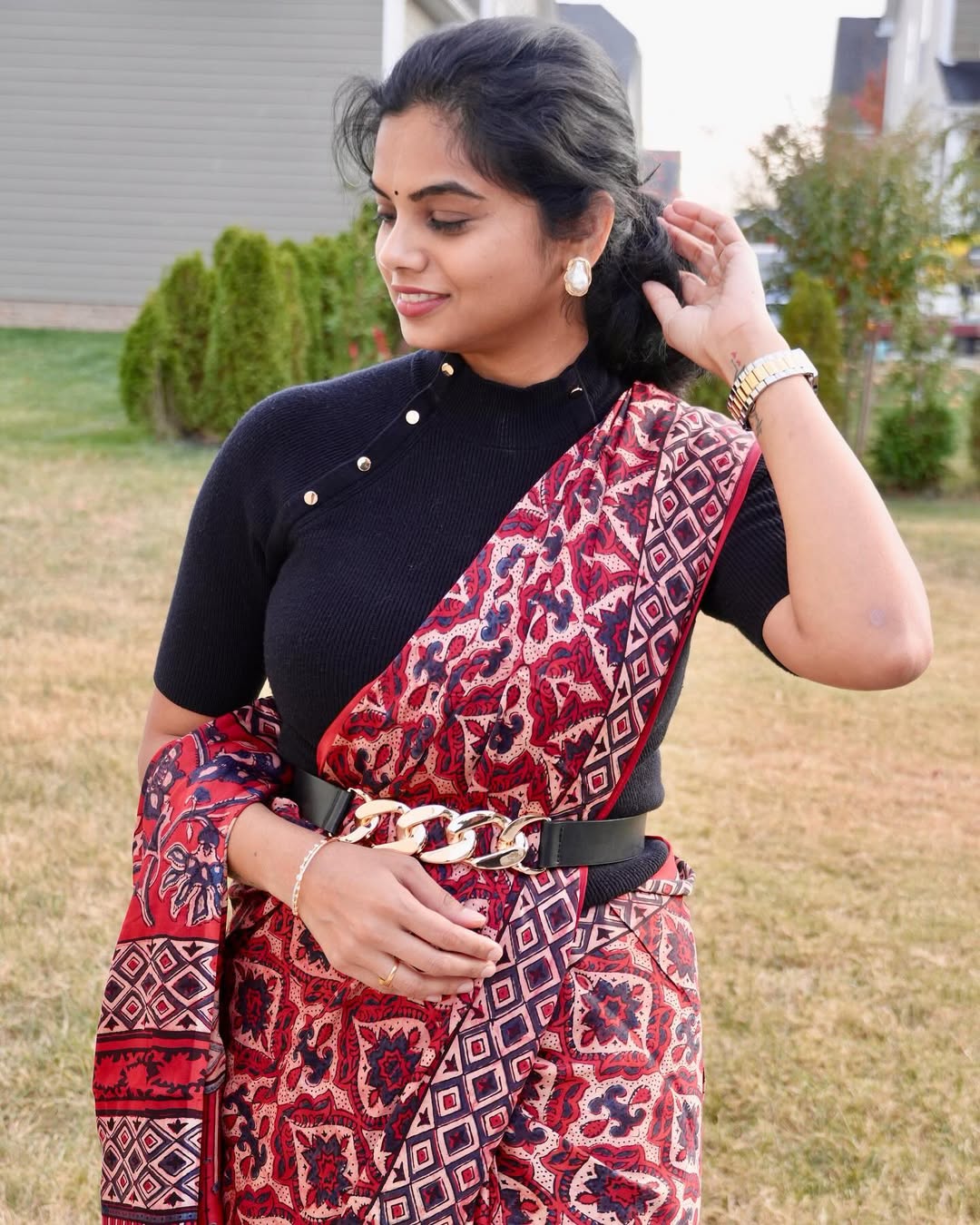 Woman wearing a red and black ajrakh saree with geometric and floral patterns by Kawaii outdoors