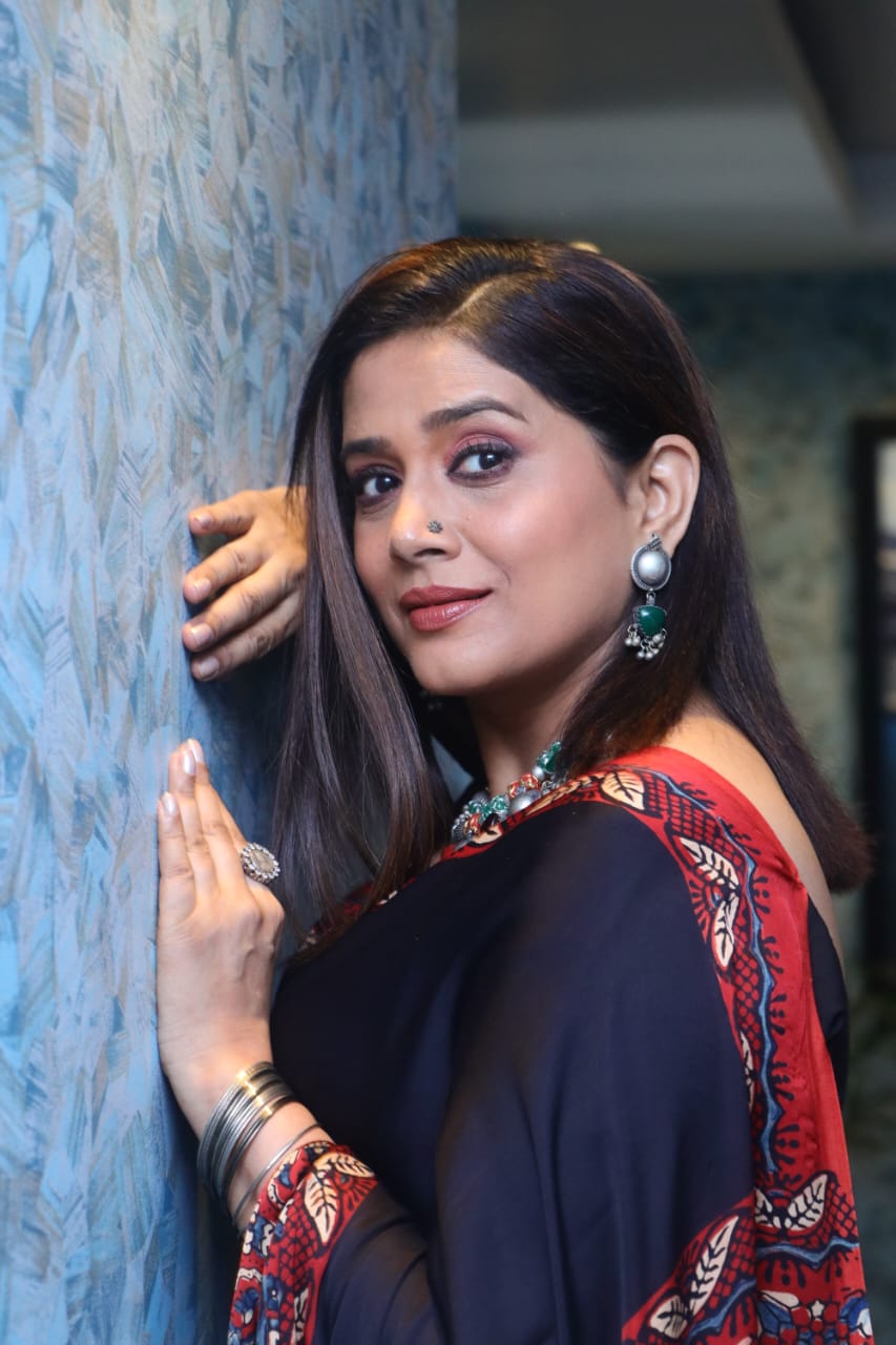 Woman wearing Kawaii ajrakh saree with traditional red and black print and silver jewelry
