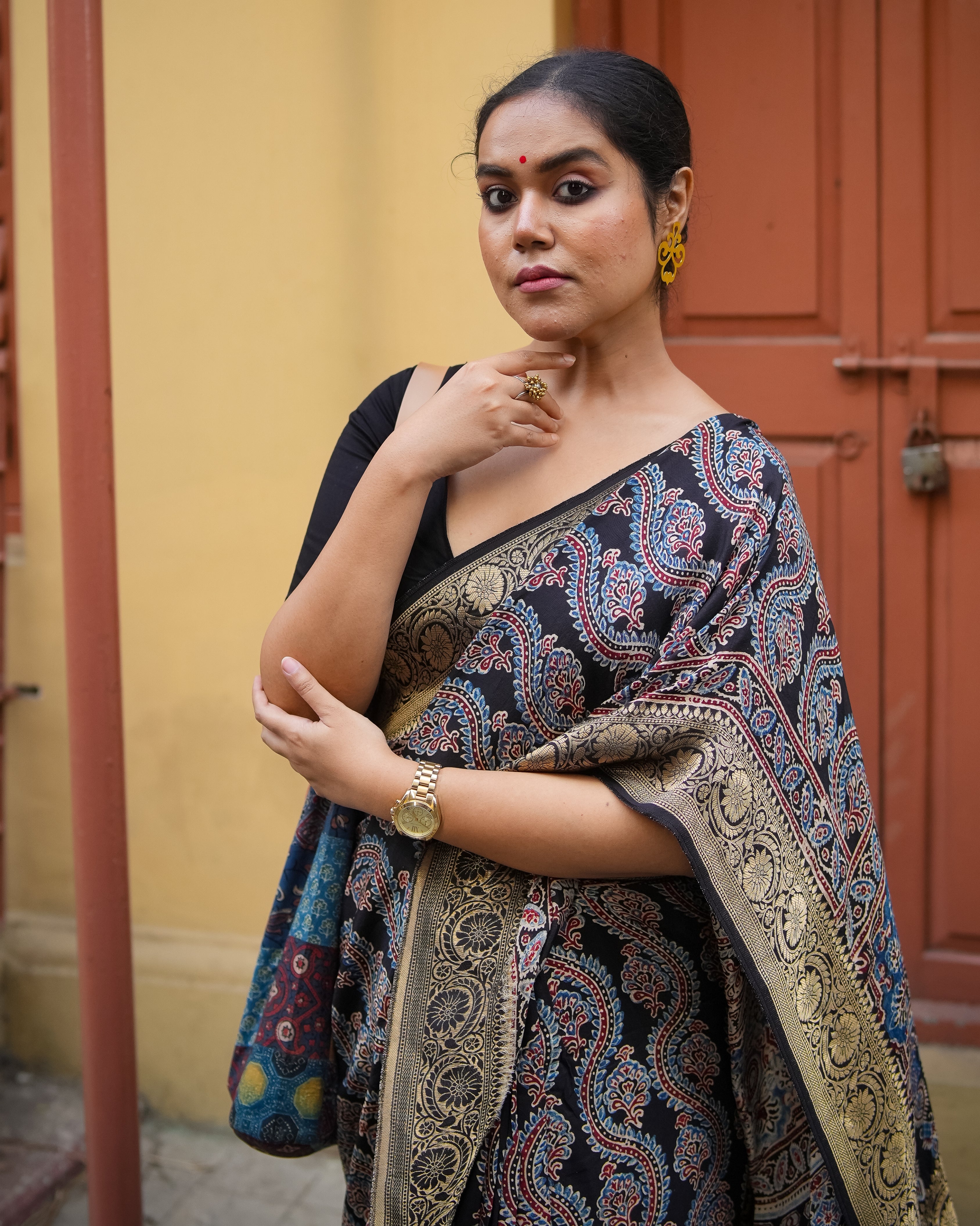 Woman wearing a black and gold patterned ajrakh saree by Kawaii with intricate traditional designs
