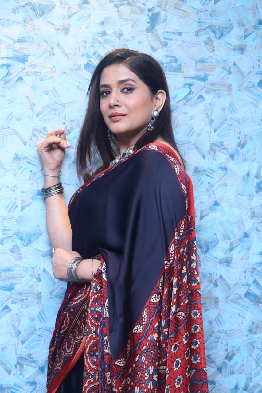 Woman wearing a traditional Kawaii ajrakh saree with red and navy blue intricate patterns