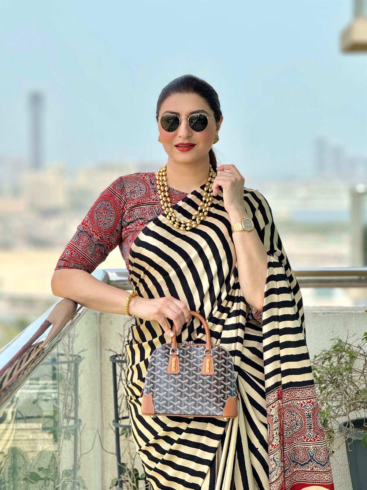 Kawaii ajrakh saree with black and white stripes and red traditional patterns worn with gold jewelry