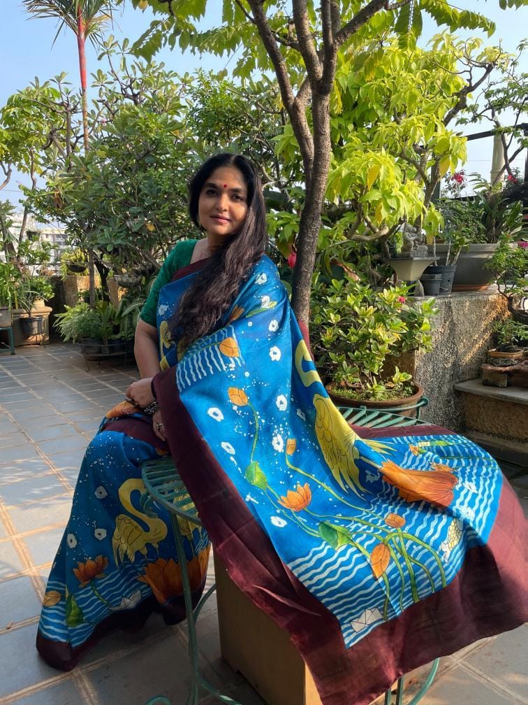 Kawaii blue Kalamkari saree featuring floral and bird motifs styled as a batik saree draped on a woman