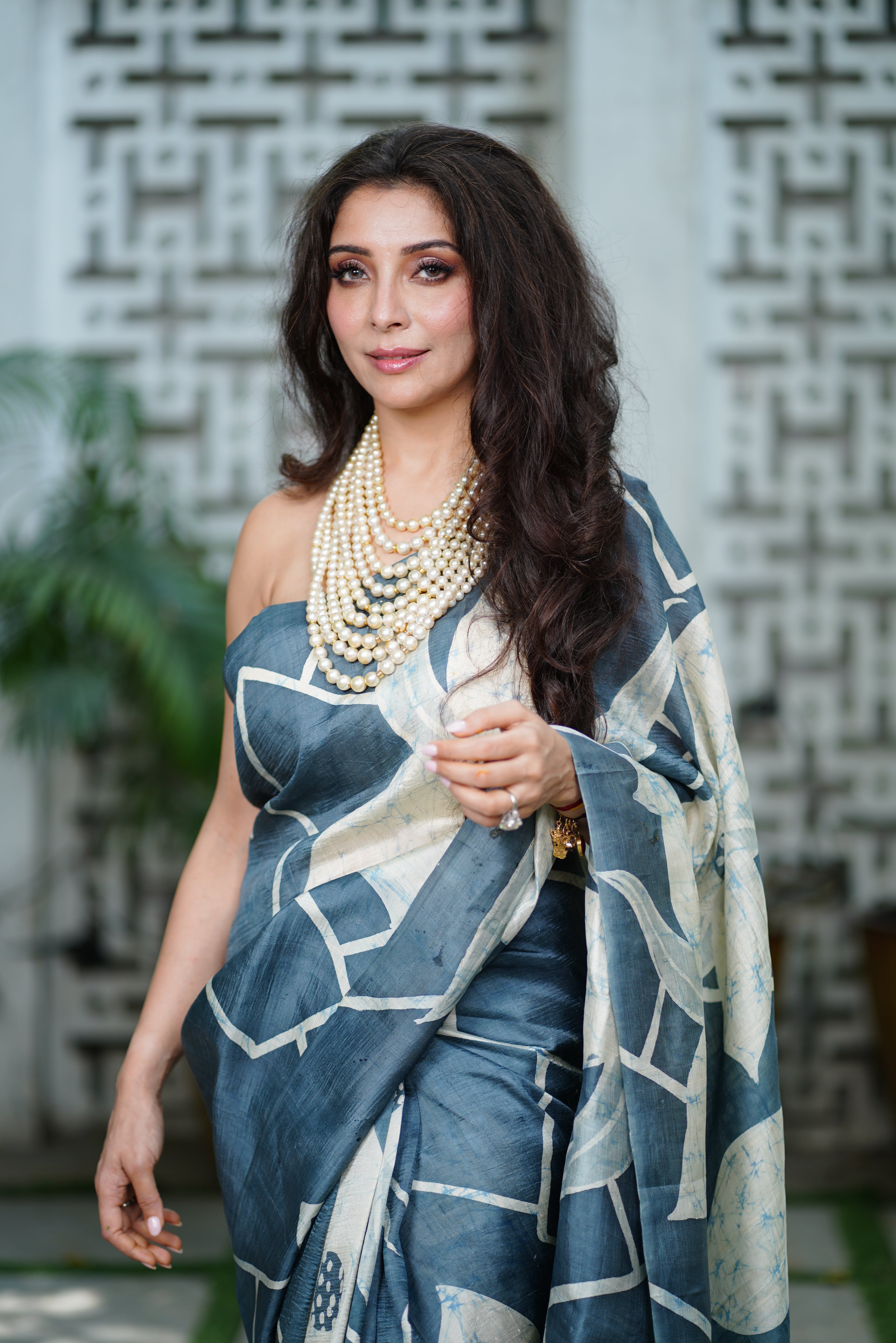 Woman wearing a blue and white batik saree by Kawaii with pearl jewelry