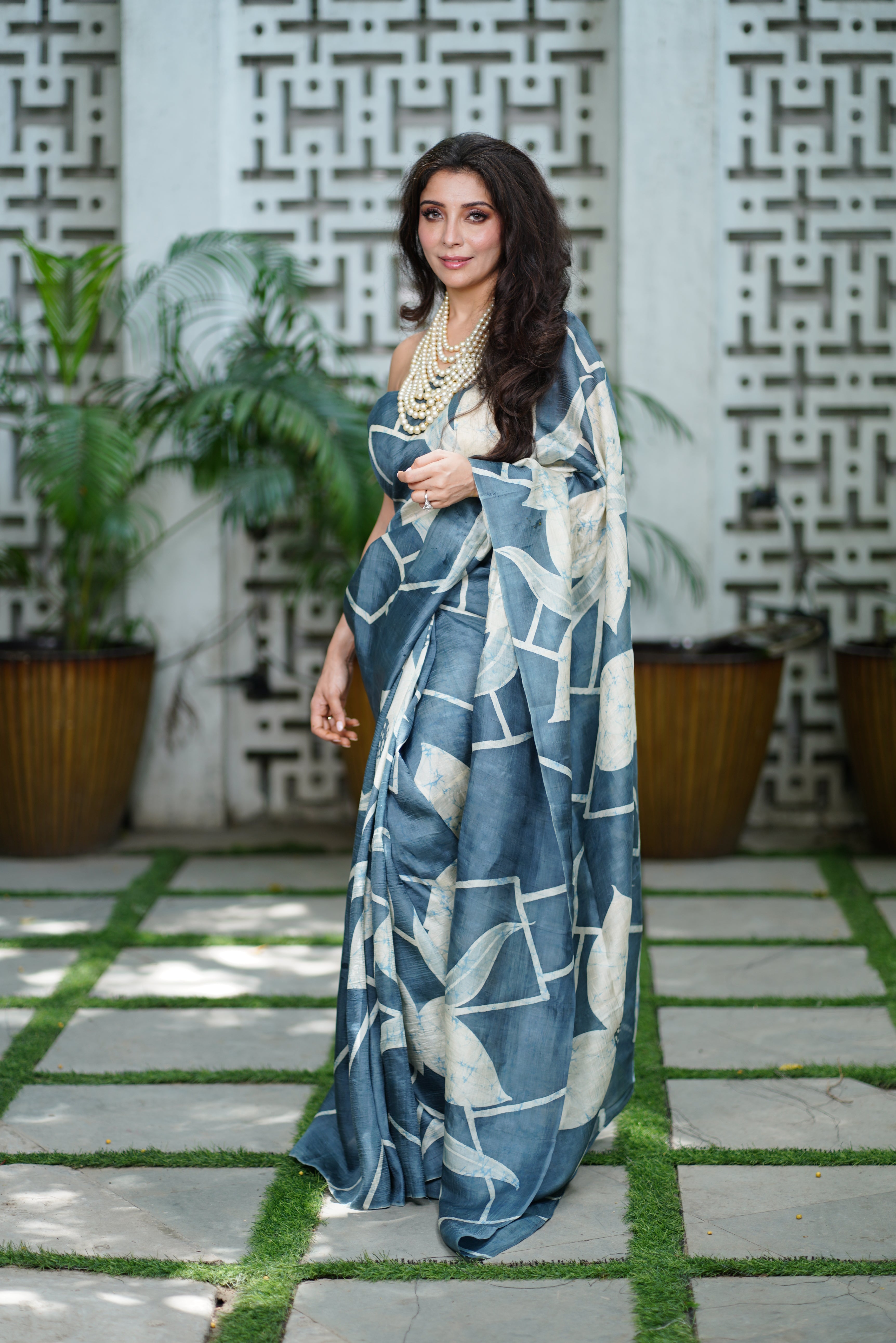 Woman wearing a blue and white Kawaii batik saree with geometric and floral patterns outdoors