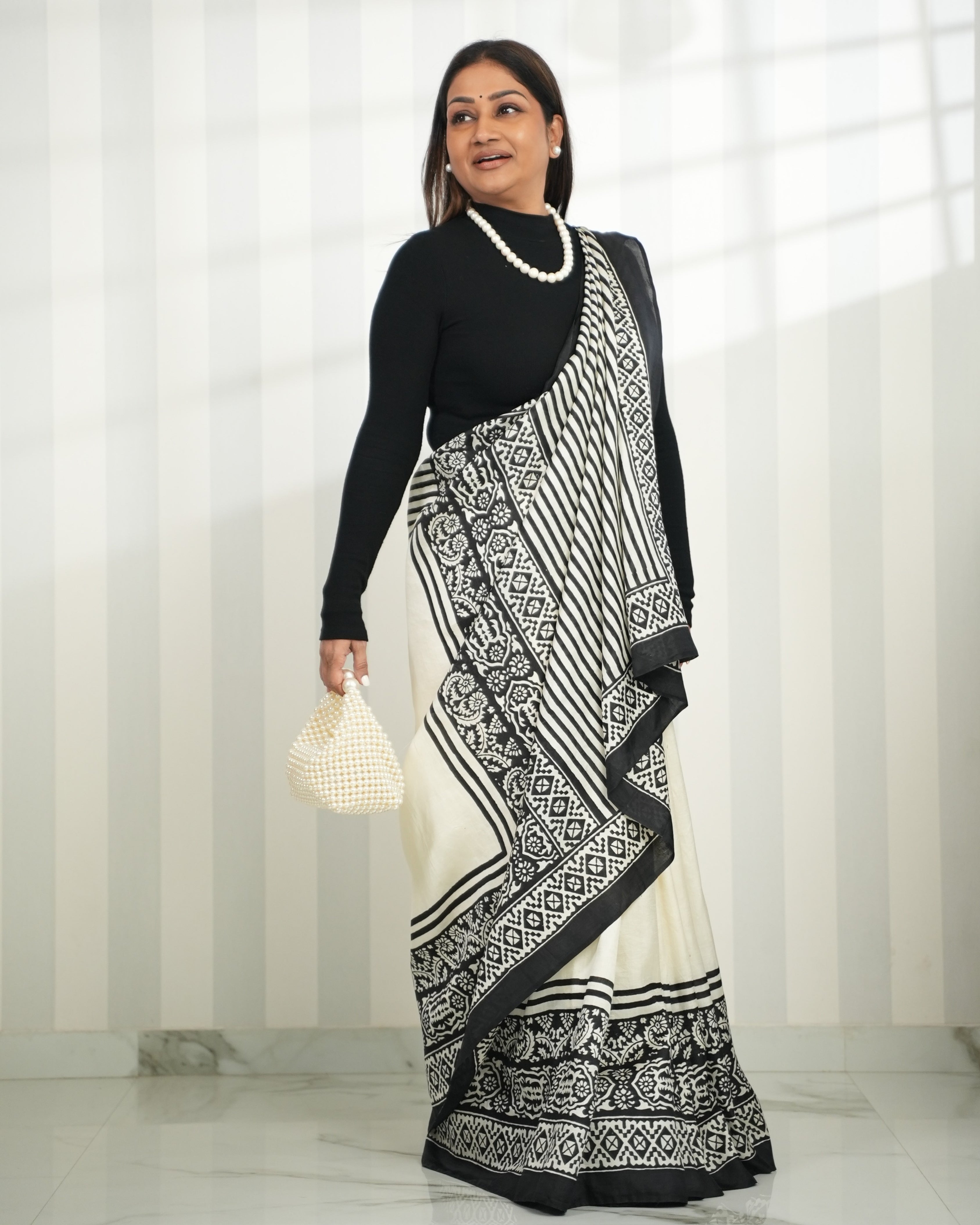 Elegant block print saree in black and white with intricate patterns, styled with a black top