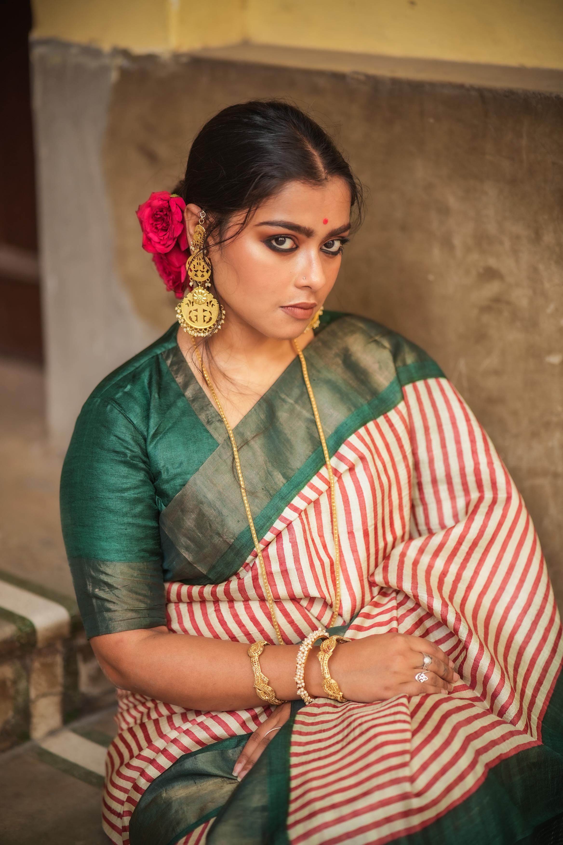 Woman wearing Kawaii block print saree with red and white stripes and green blouse with traditional jewelry