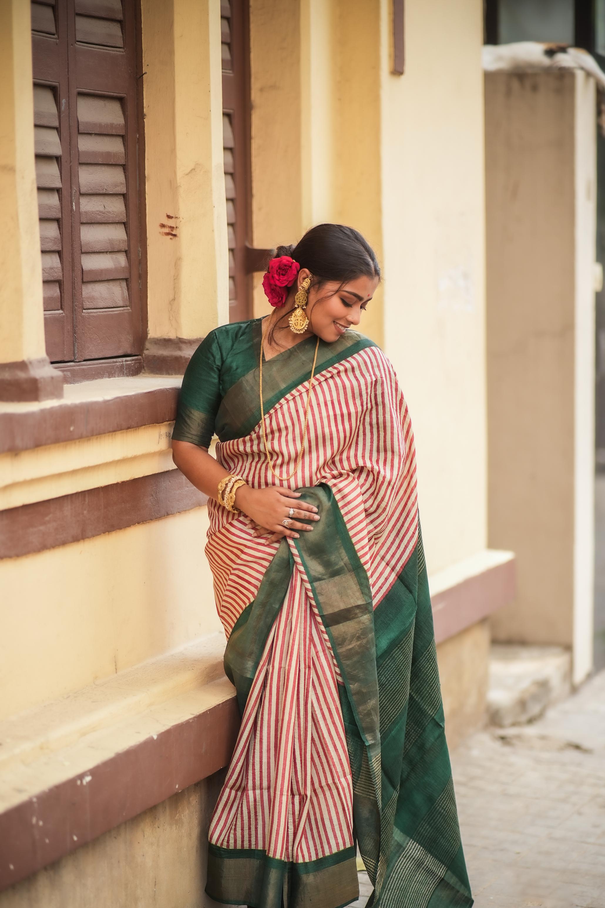 Kawaii block print saree in green and red stripes worn by woman with floral hair accessory