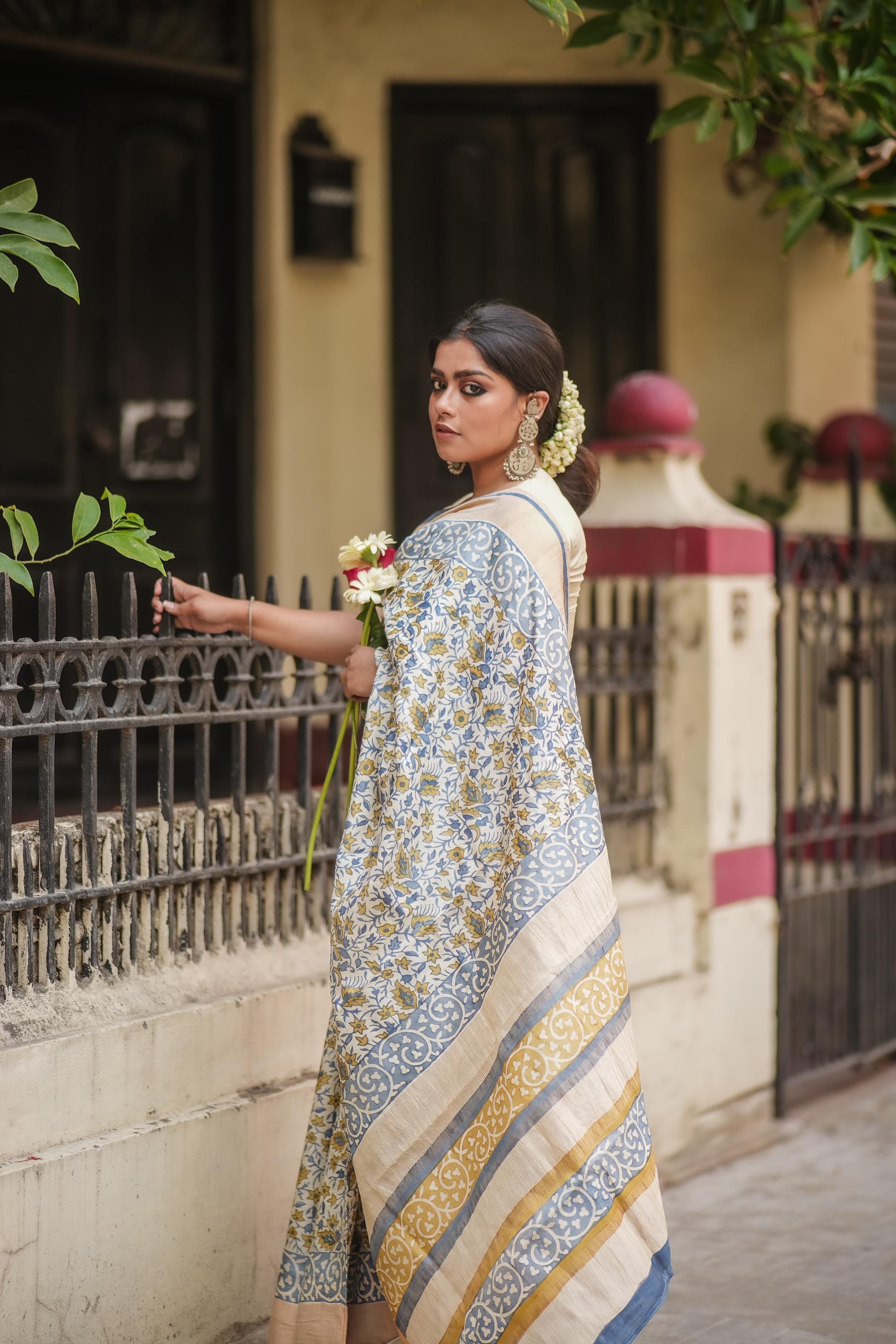 Kawaii block print saree featuring intricate blue and gold floral patterns worn by woman with traditional jewelry