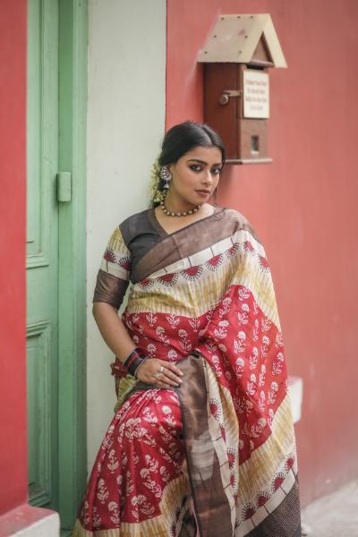 Woman wearing a red and beige Kawaii block print saree with floral patterns and brown border