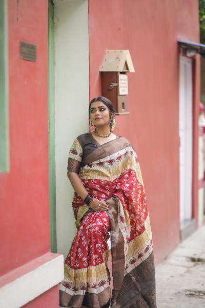 Woman wearing a colorful Kawaii block print saree with red and beige patterns standing outdoors
