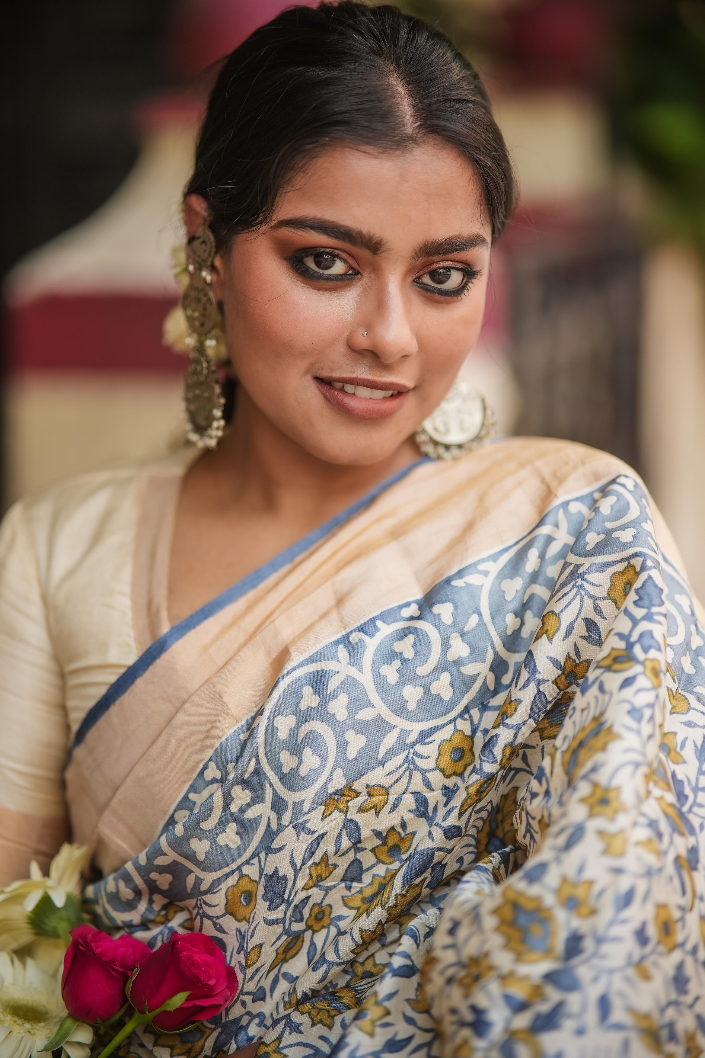 Woman wearing Kawaii block print saree in beige and blue floral design with traditional jewelry
