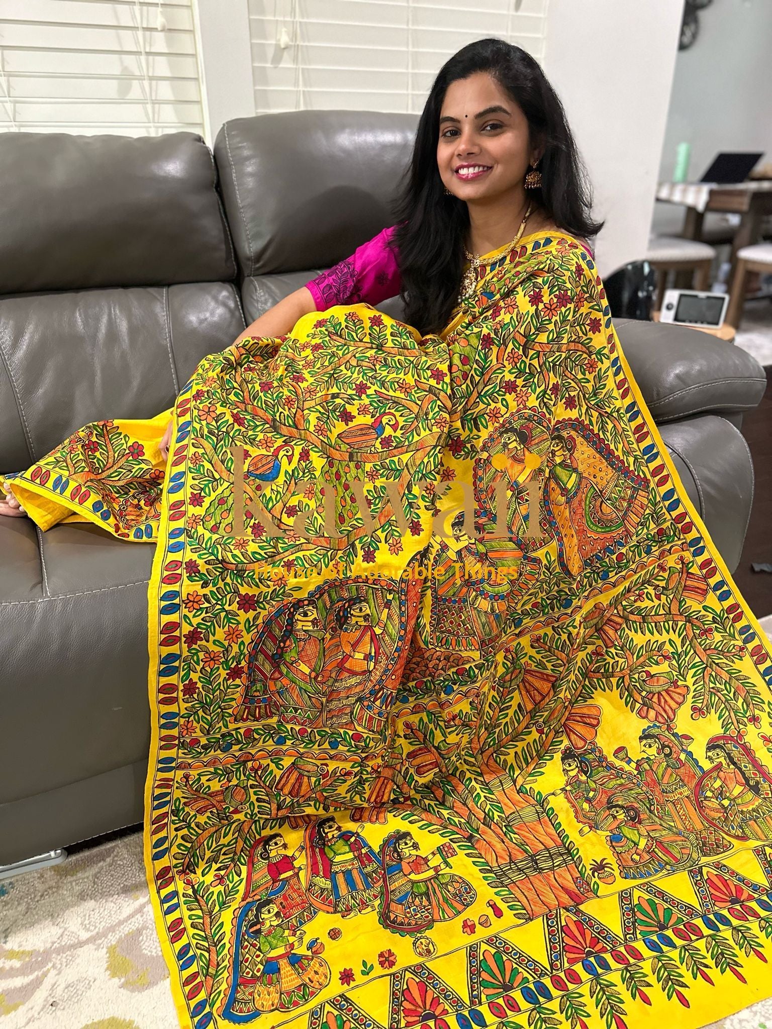 Kawaii yellow madhubani saree with intricate traditional artwork worn by a smiling woman