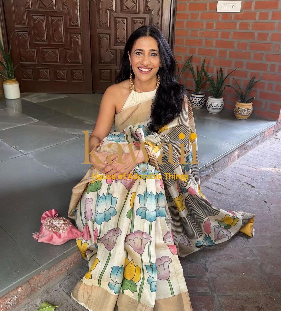 Kalamkari saree in cream with colorful floral patterns, elegantly draped for a traditional look