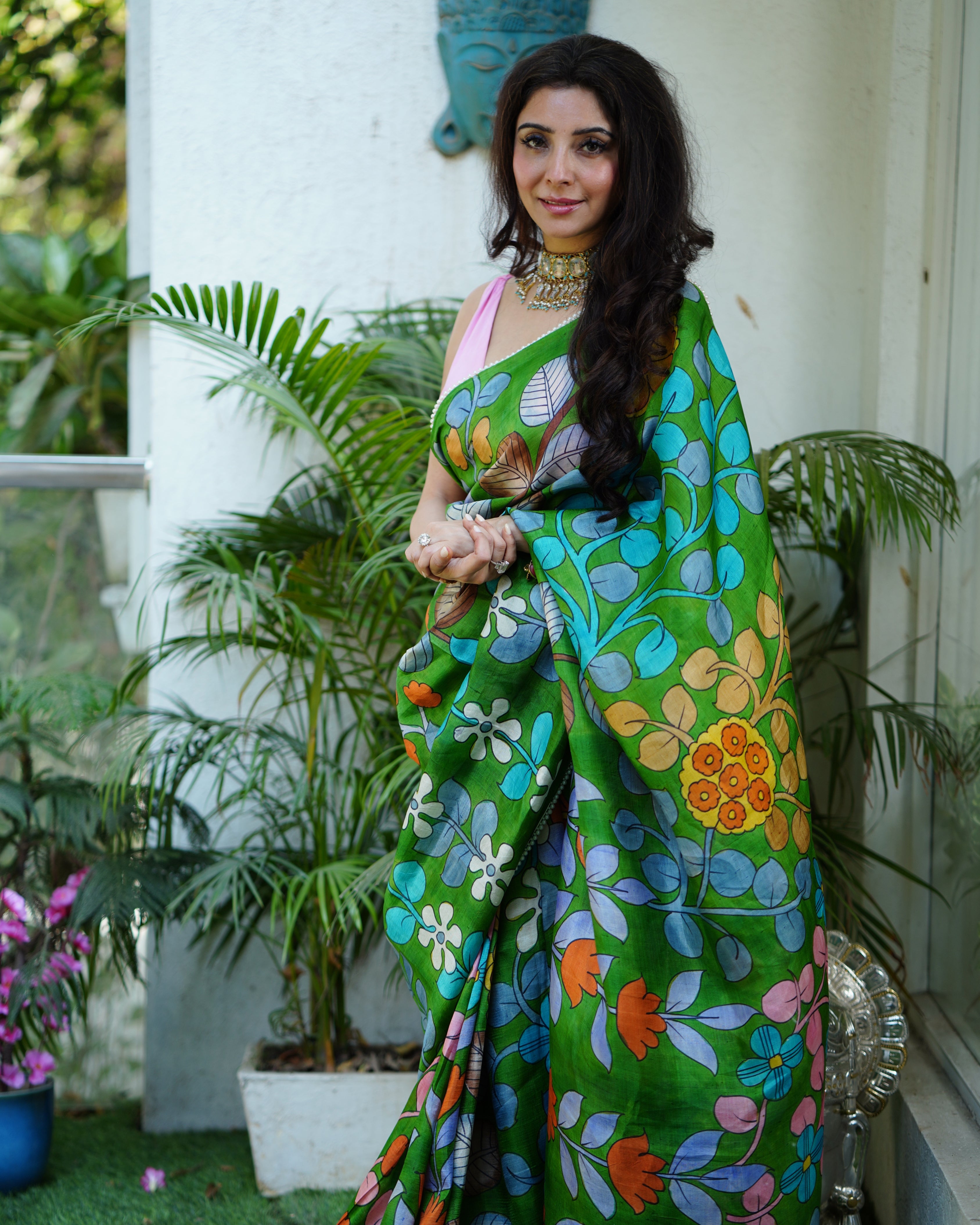 Kawaii green kalamkari saree with floral patterns worn by woman with long hair and necklace