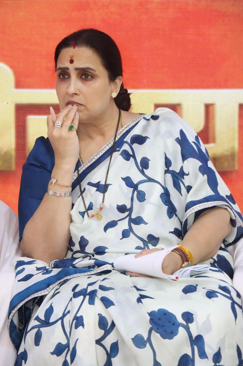 Woman wearing white and blue floral printed kalamkari saree sitting thoughtfully