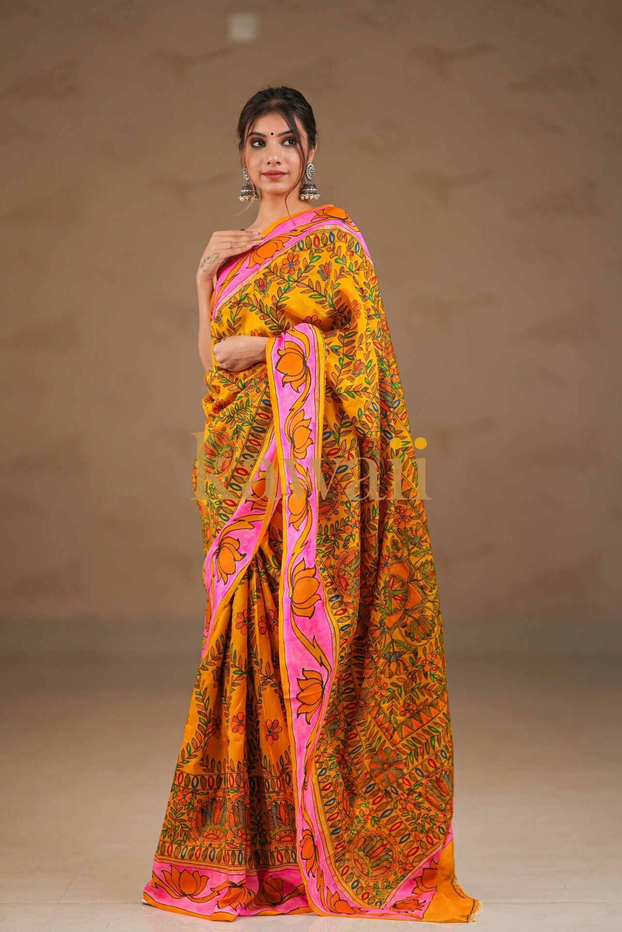 Kalamkari saree in vibrant orange with intricate floral patterns and a pink border, crafted from soft fabric