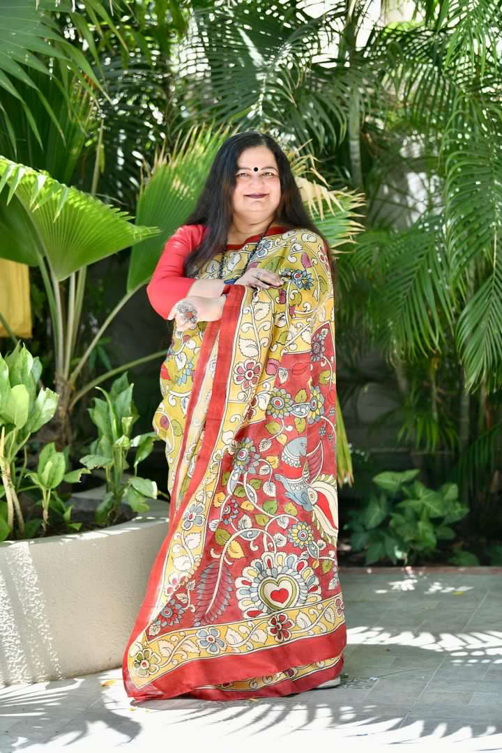 Woman wearing a colorful Kawaii kalamkari saree with traditional floral and bird patterns standing outdoors