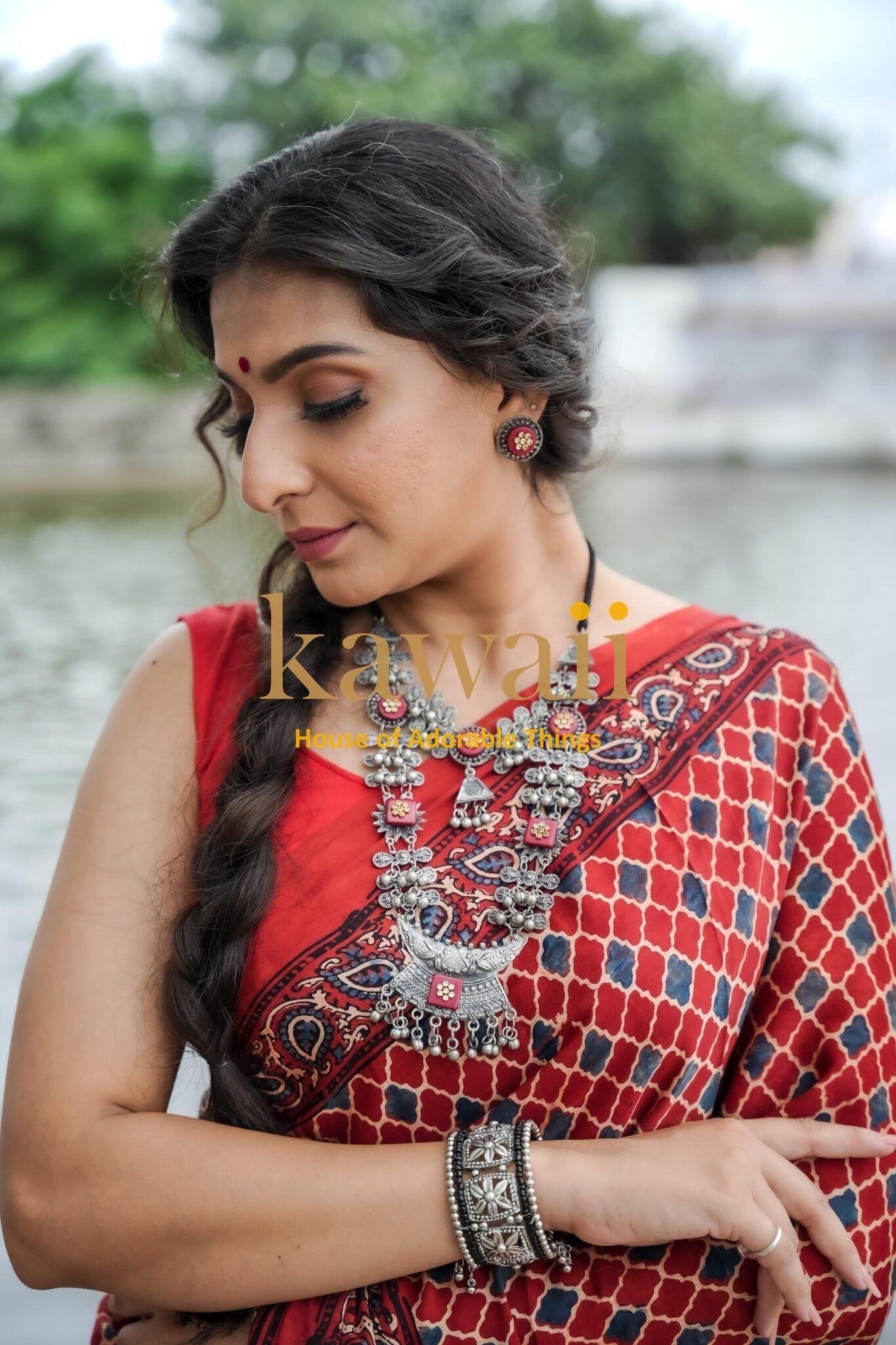 Woman wearing red patterned ajrakh saree with traditional silver jewelry by Kawaii