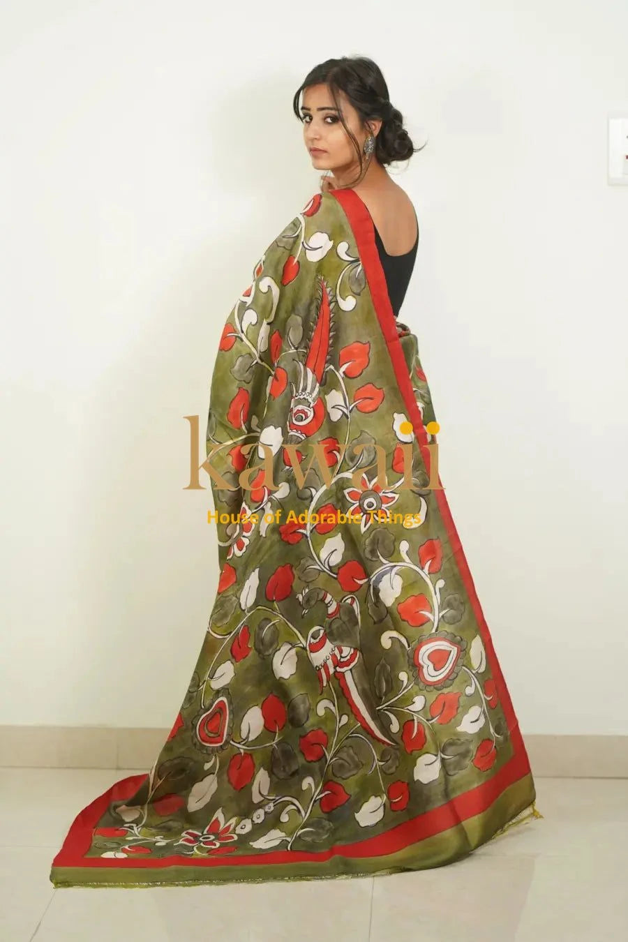 Kawaii kalamkari saree in olive green with vibrant floral patterns and red border draped on model