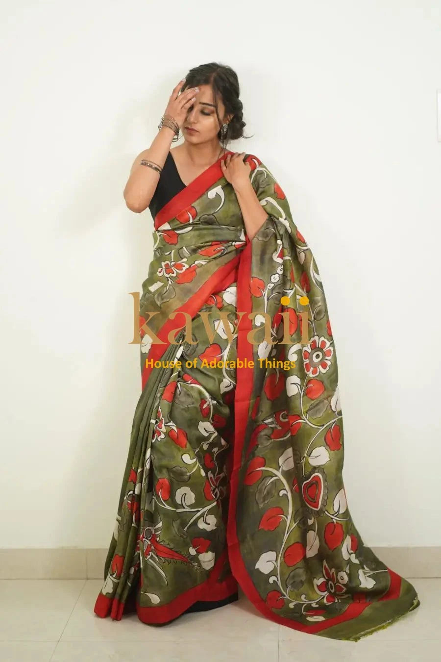 Kawaii green and red kalamkari saree with floral patterns worn by a woman