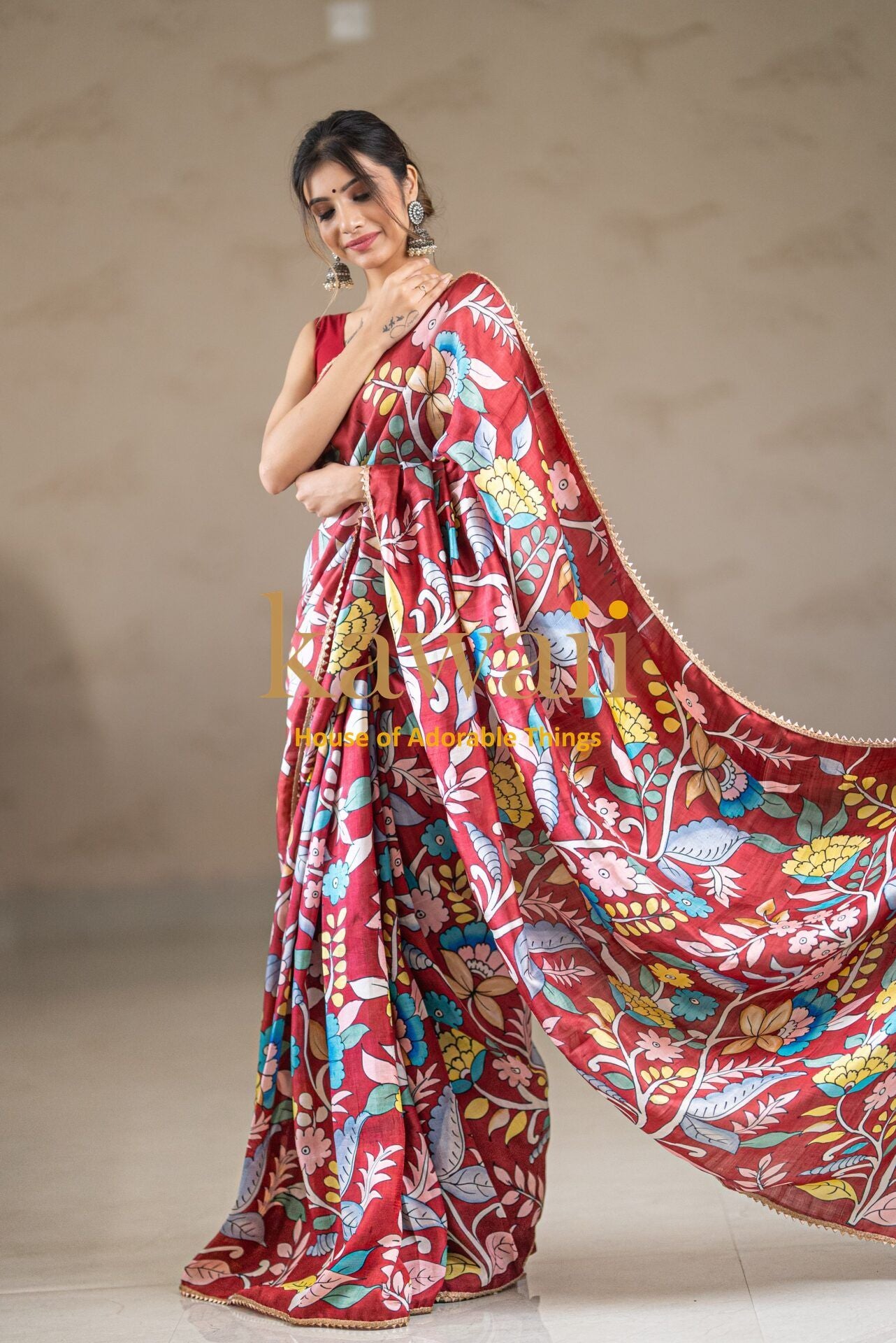 Kawaii red kalamkari saree with colorful floral patterns worn by woman with matching accessories