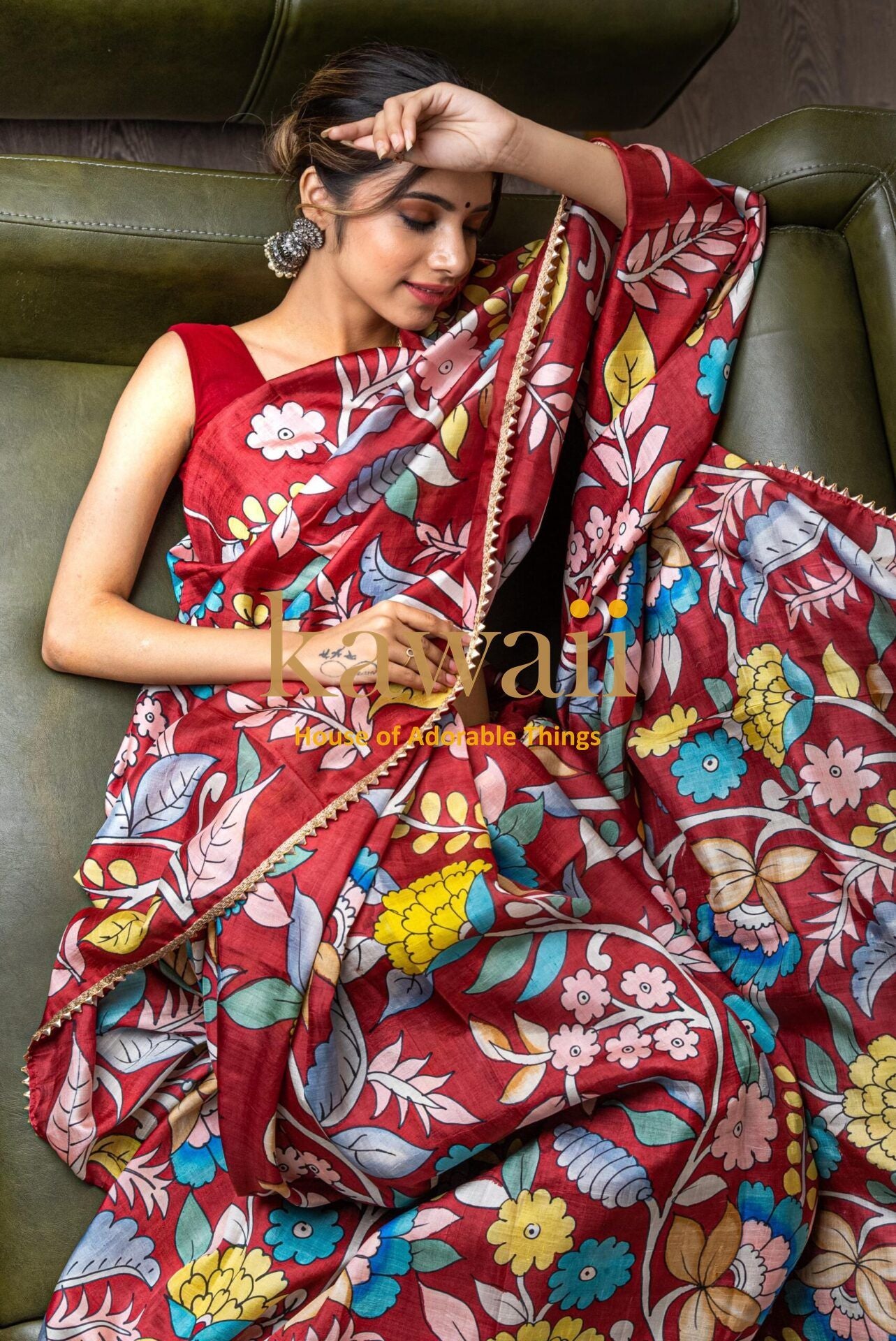 Woman wearing vibrant red kalamkari saree with colorful floral and leaf patterns from Kawaii