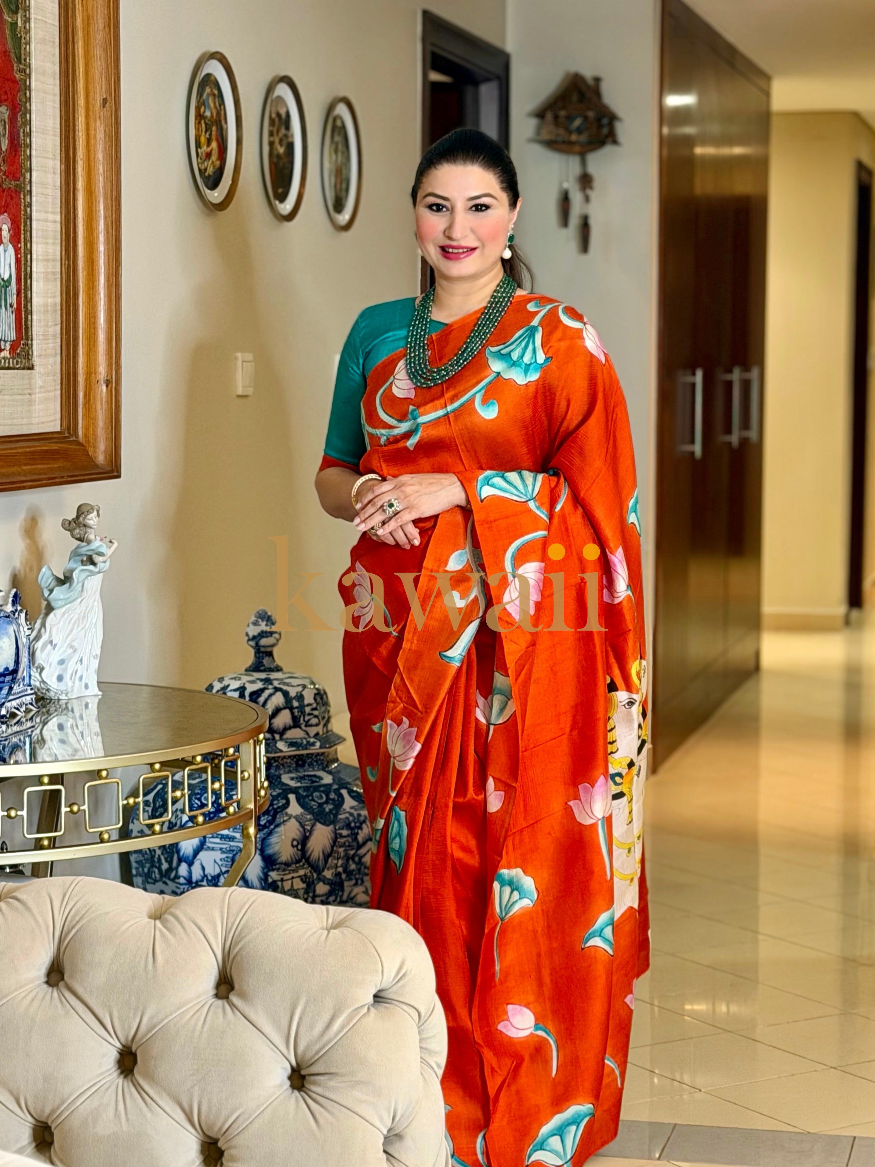 Elegant model wearing a vibrant pichwai saree with floral designs in an upscale indoor setting