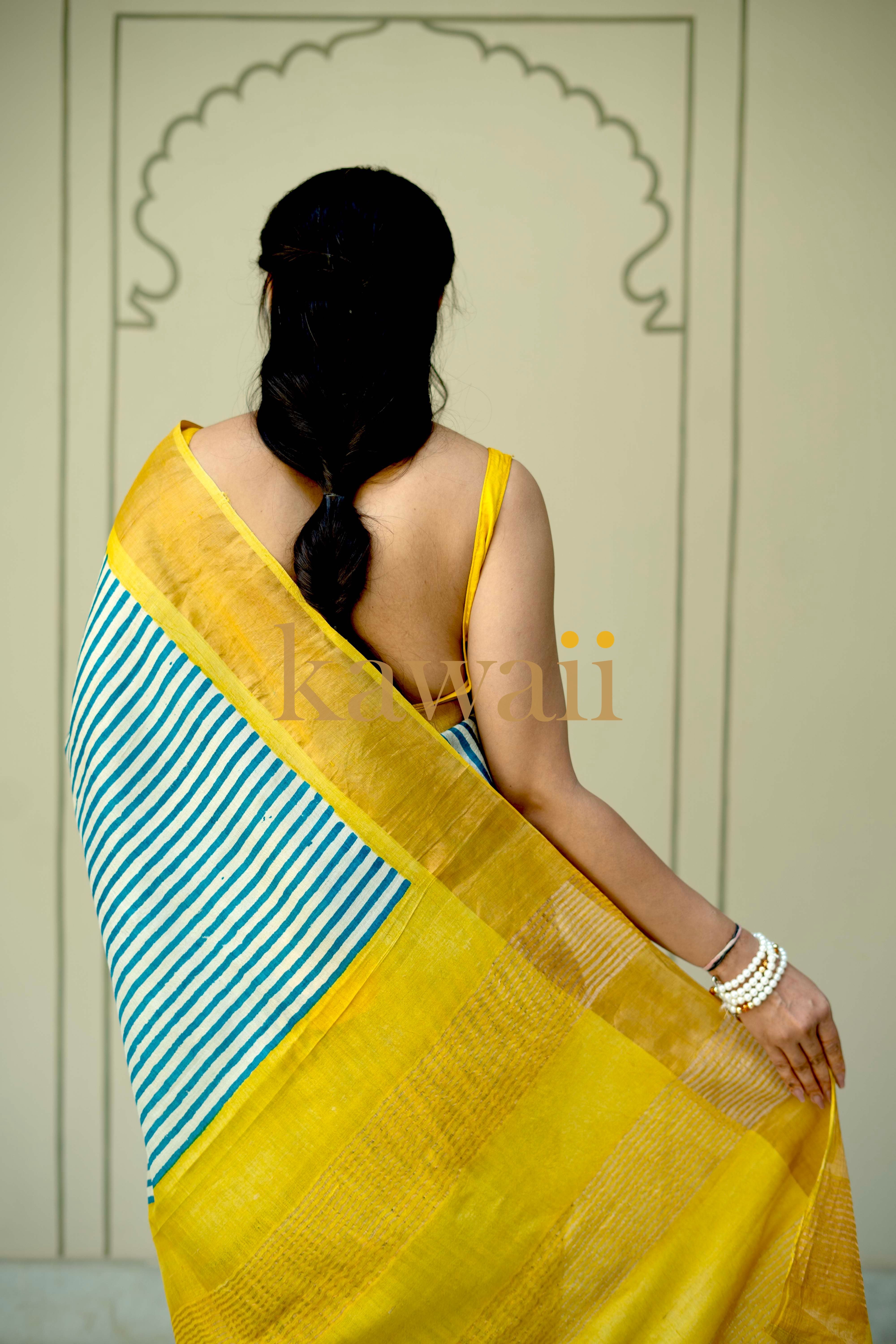 Yellow Tussar silk saree with blue and white block print border, showcasing elegant craftsmanship