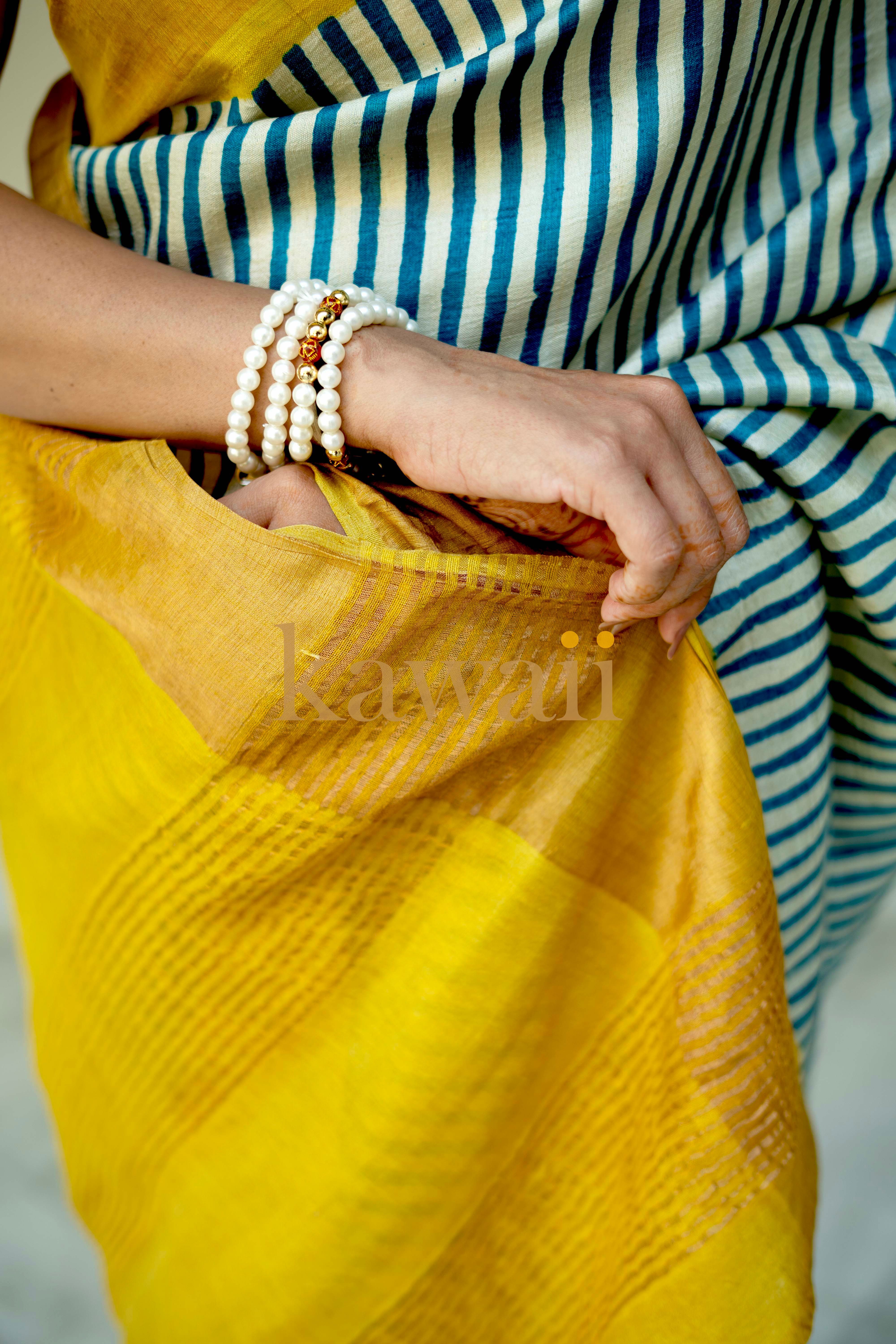 Elegant yellow block print tussar silk saree with blue and white stripes, showcasing handcrafted details