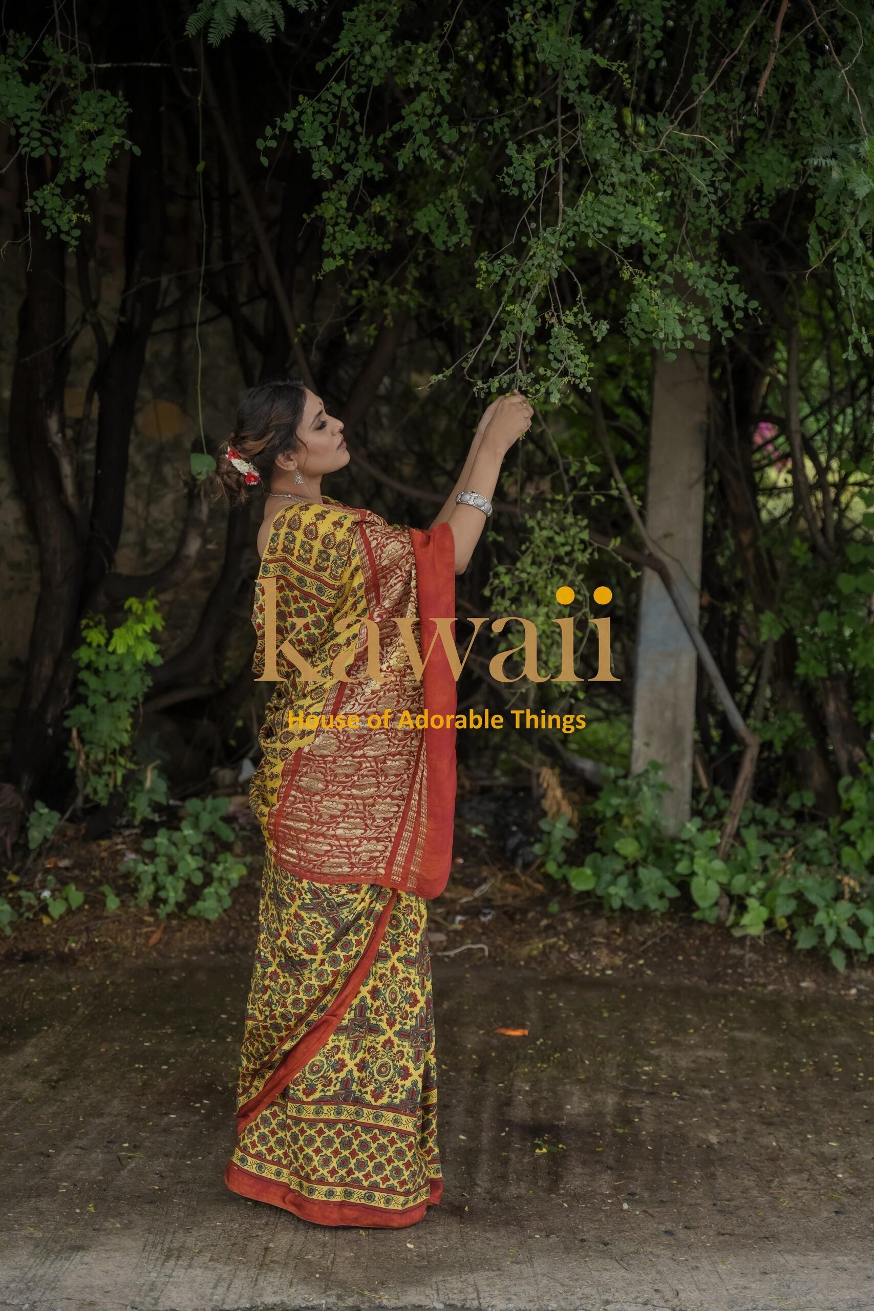 Woman wearing a traditional Kawaii ajrakh saree with intricate patterns in an outdoor garden setting