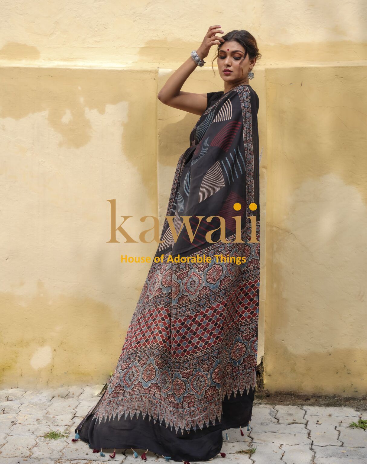 Kawaii ajrakh saree with intricate traditional patterns worn by woman standing against yellow wall
