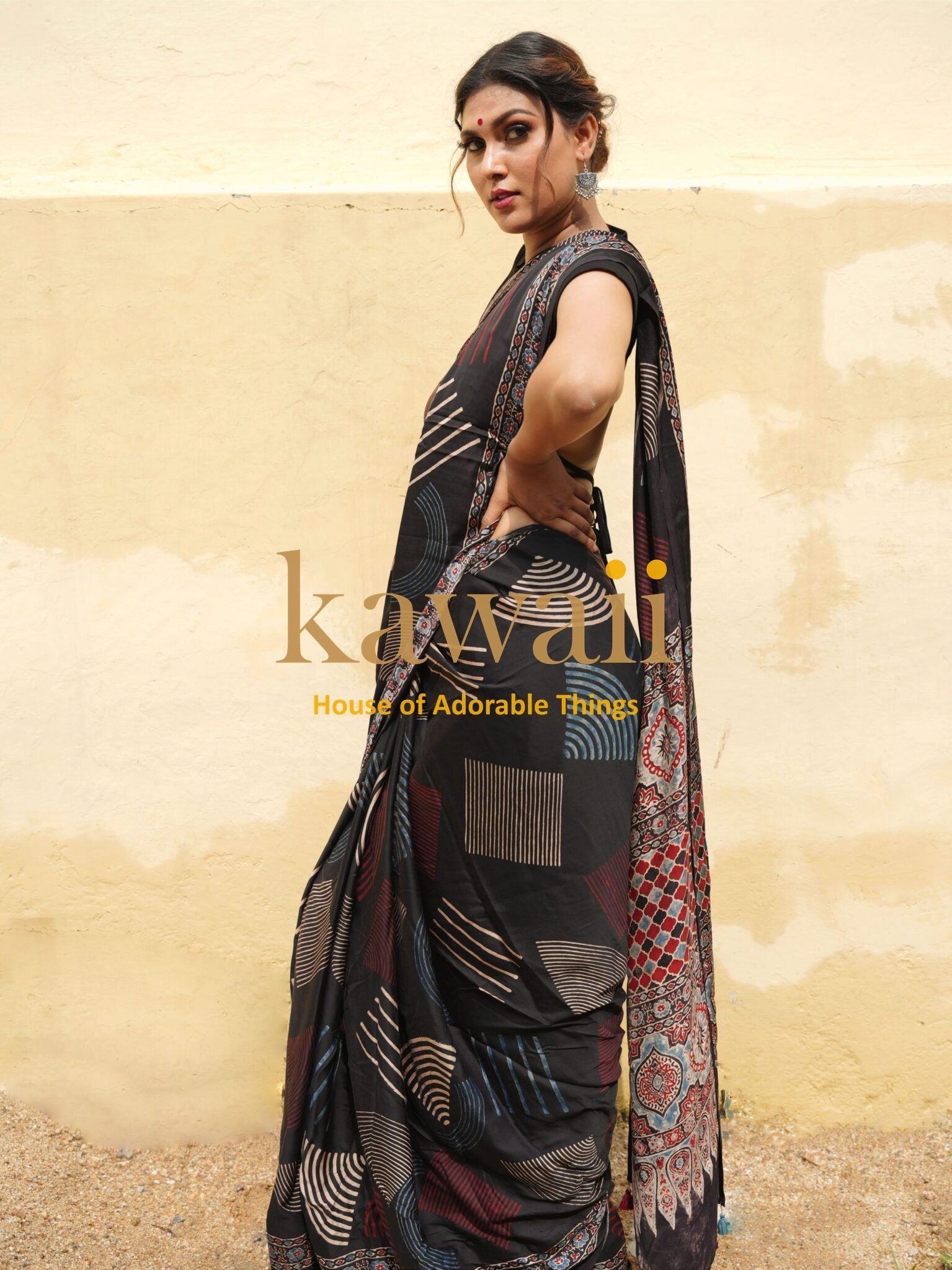 Woman wearing a black patterned ajrakh saree by Kawaii with detailed traditional designs