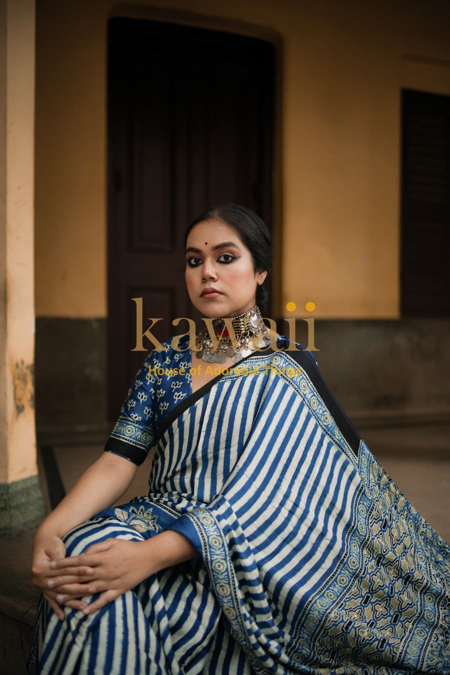 Woman wearing a blue and white striped ajrakh saree with traditional patterns by Kawaii