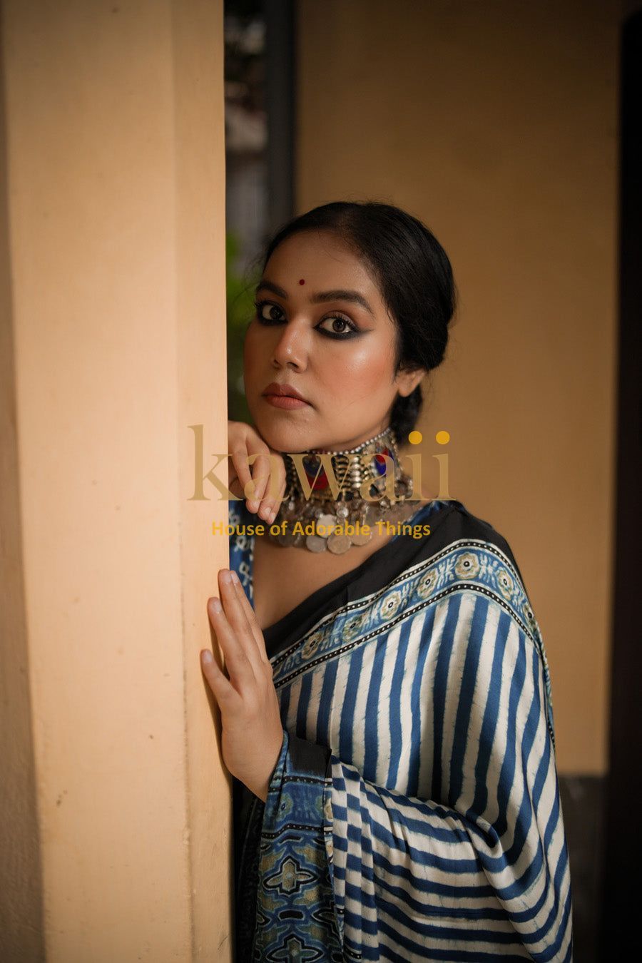 Woman wearing a blue and white striped ajrakh saree with traditional patterned border by Kawaii