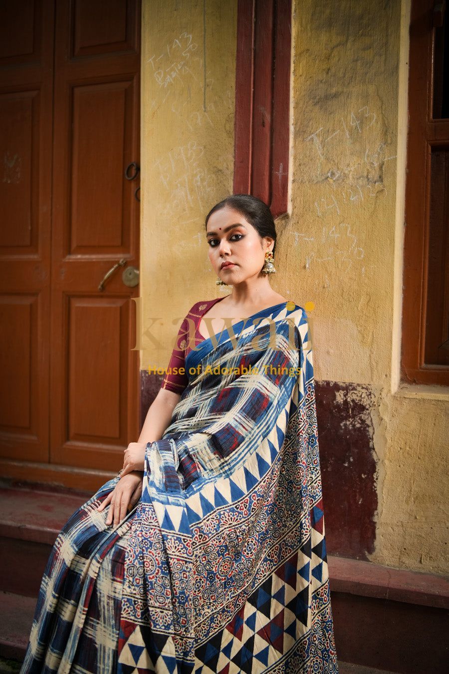 Kawaii ajrakh saree with traditional geometric and floral patterns worn by a seated woman