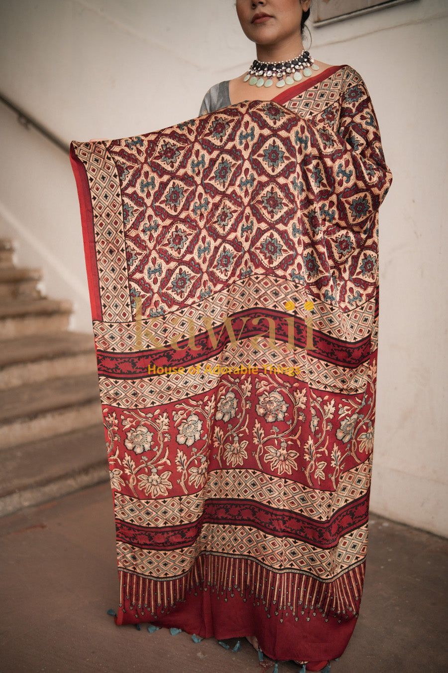 Woman wearing traditional Kawaii ajrakh saree with intricate red and beige patterns and floral designs