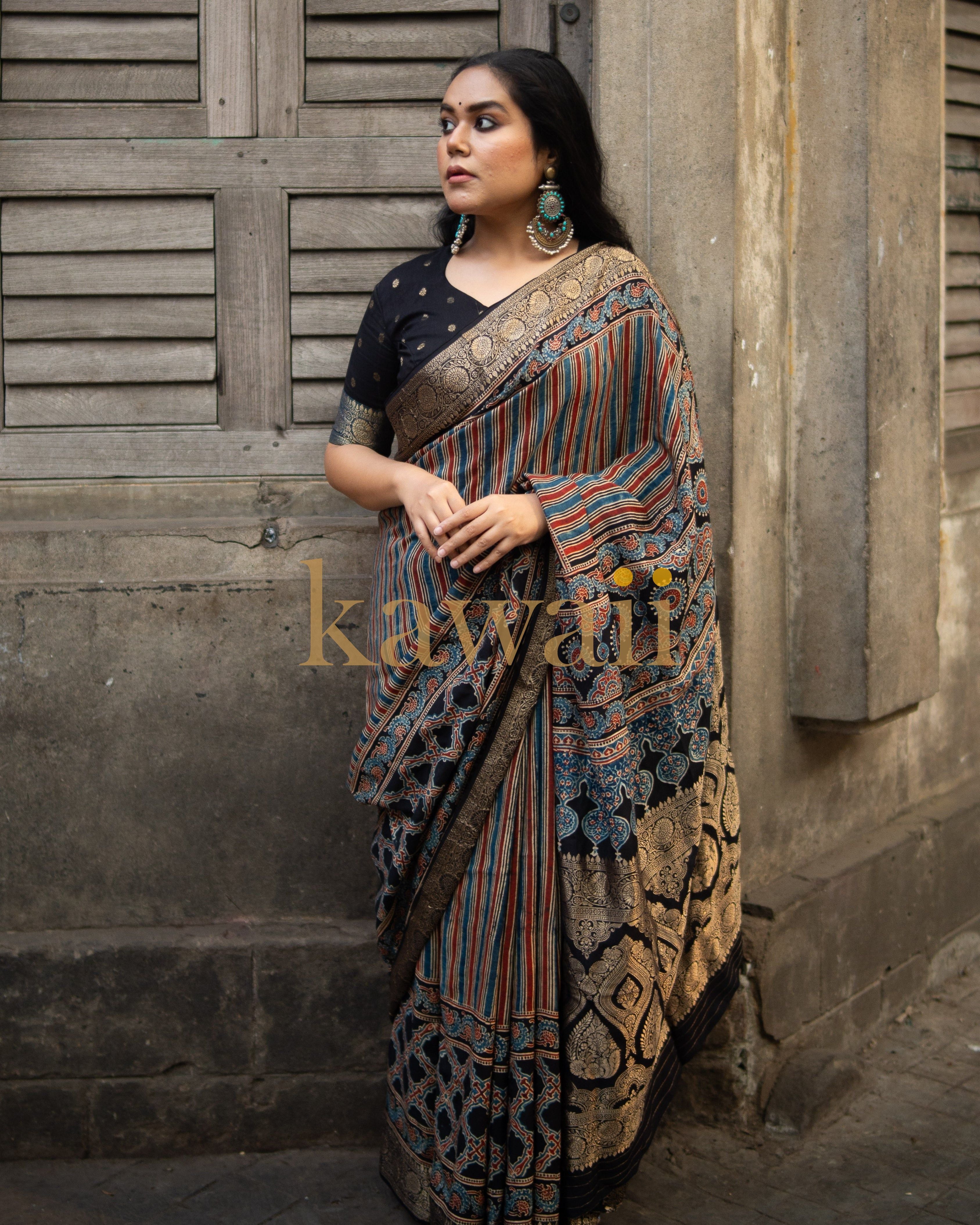 Woman wearing a traditional ajrakh saree with intricate patterns and a black blouse by Kawaii