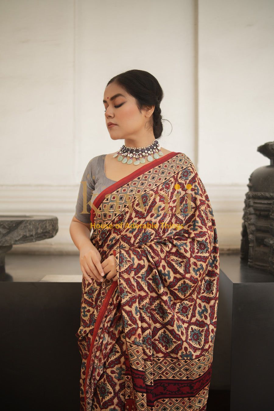 Woman wearing a traditional Kawaii ajrakh saree with intricate geometric patterns and a silver necklace
