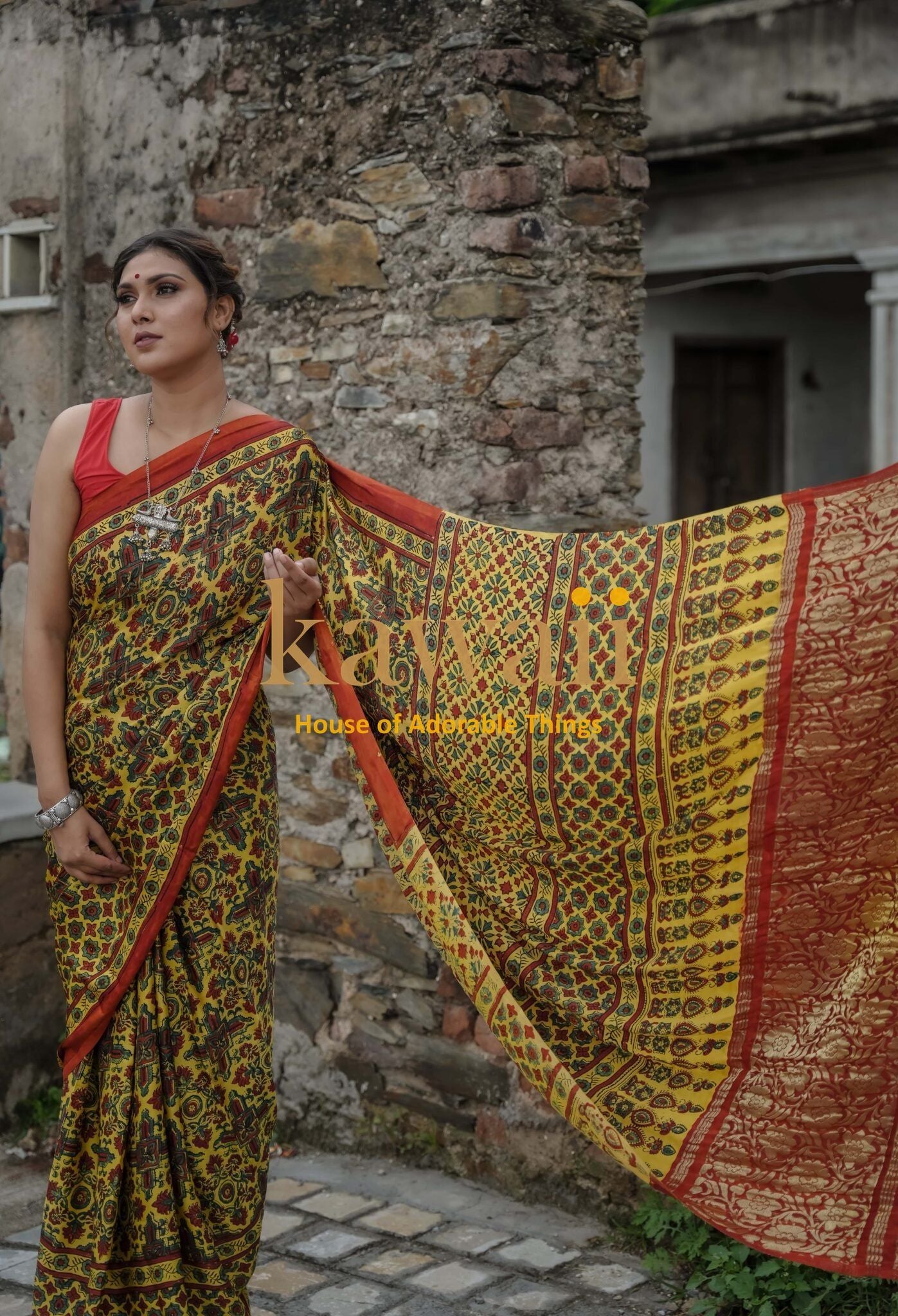 Woman wearing traditional ajrakh saree in yellow and red with intricate patterns by Kawaii