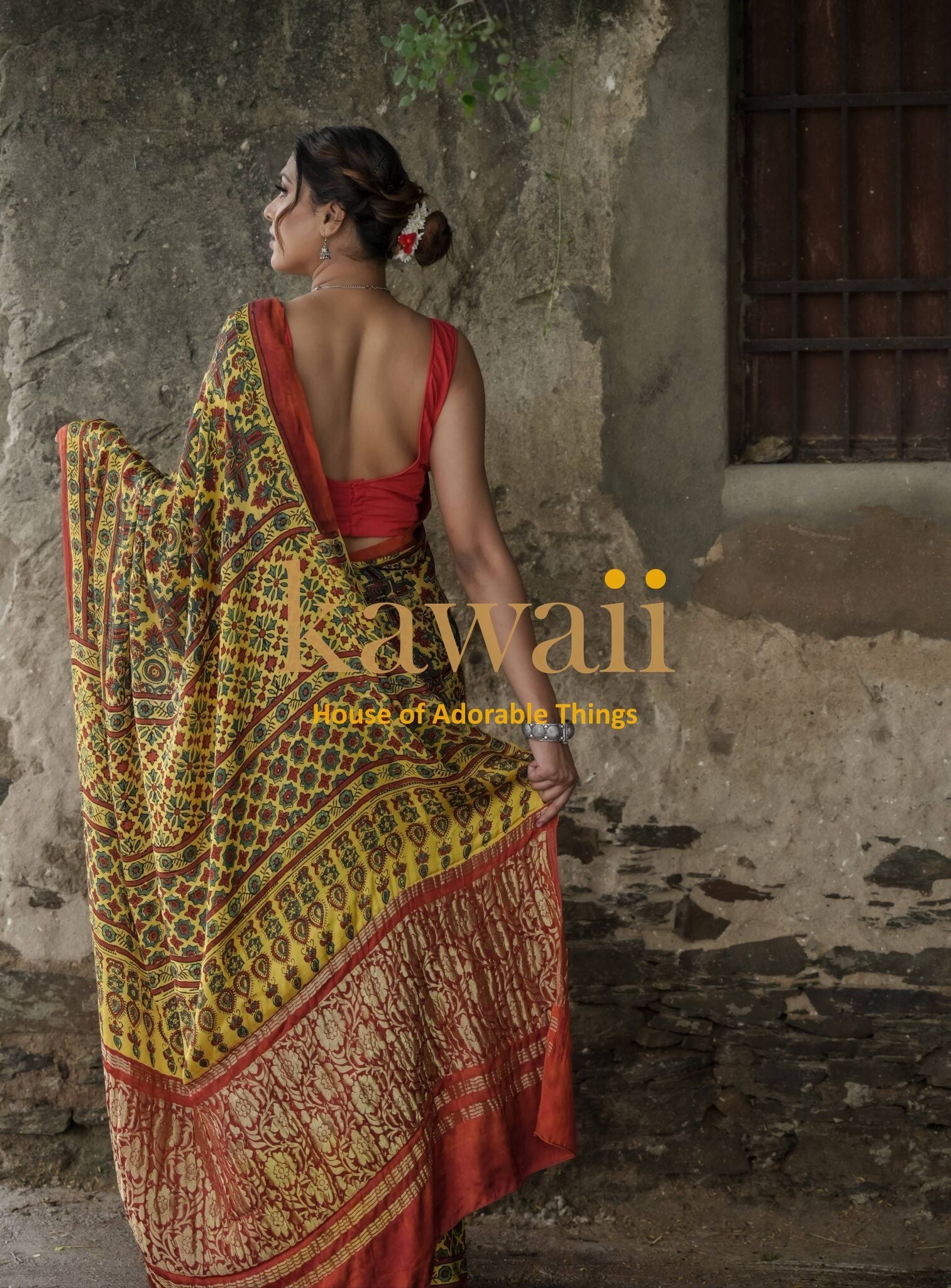 Woman wearing traditional yellow and red ajrakh saree with detailed patterns by Kawaii