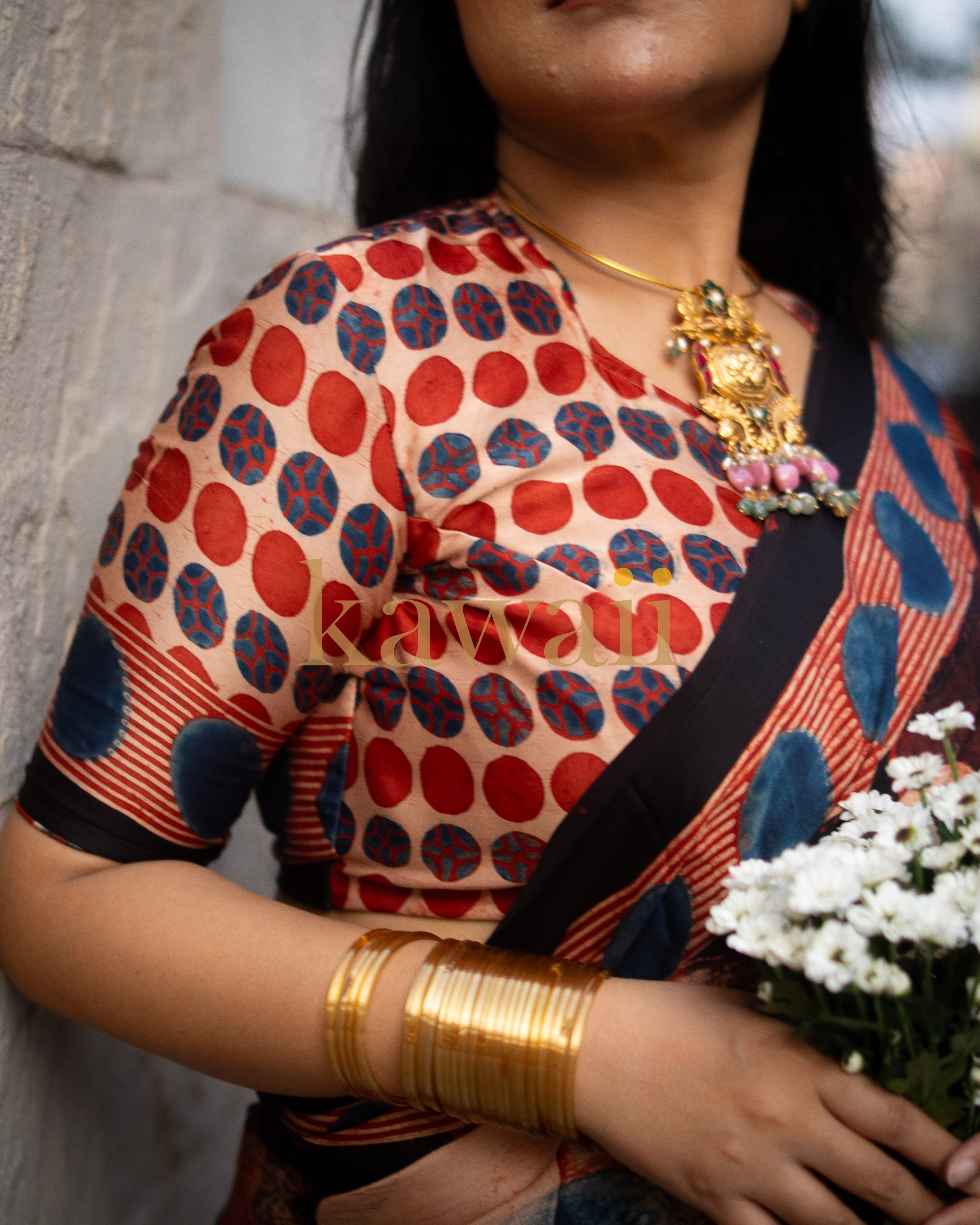 Kawaii ajrakh saree with traditional red and blue circular patterns worn with gold jewelry and bangles