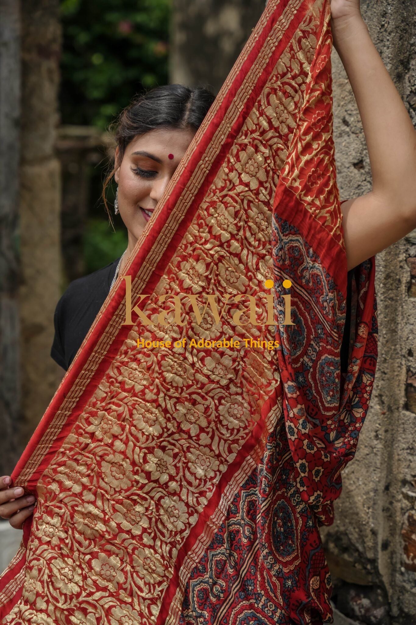 Kawaii ajrakh saree in red with intricate gold floral and geometric patterns worn by a smiling woman