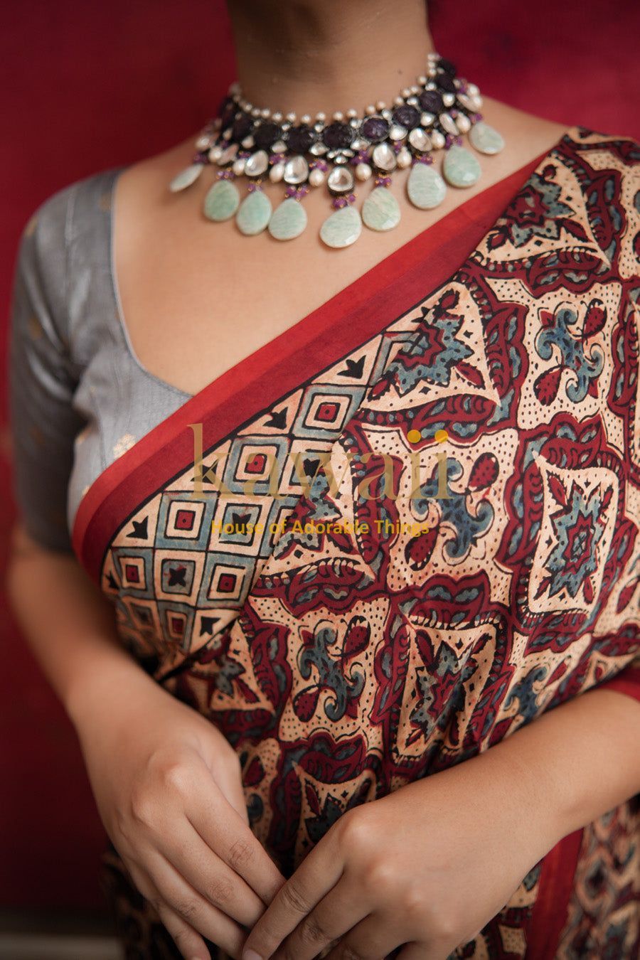 Kawaii ajrakh saree with intricate traditional patterns in red and beige worn with a silver blouse and statement necklace