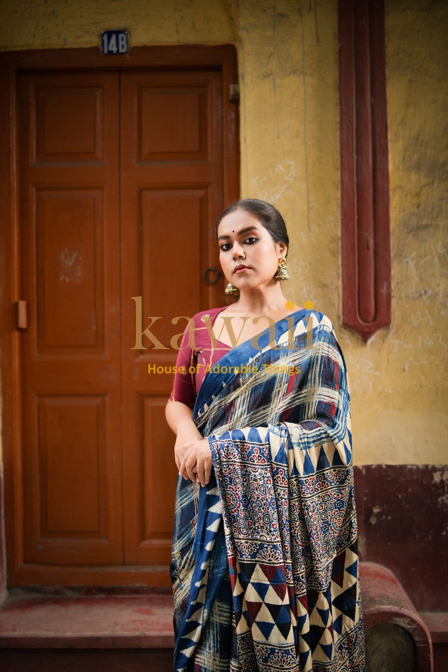 Woman wearing traditional blue and cream ajrakh saree with geometric and floral patterns by Kawaii