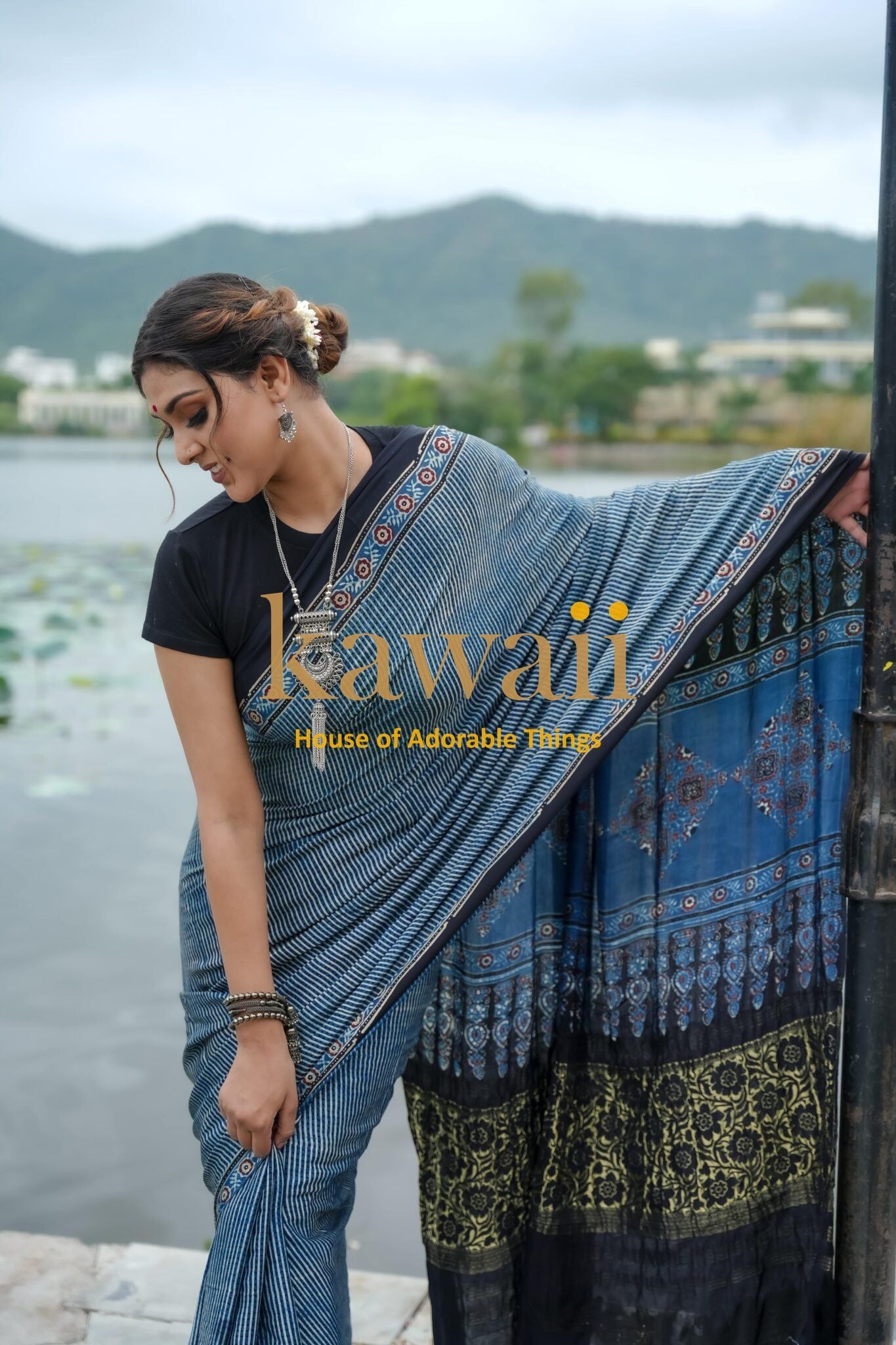 Kawaii Ajrakh saree in blue with traditional patterns worn by woman by lakeside ajrakh sarees online