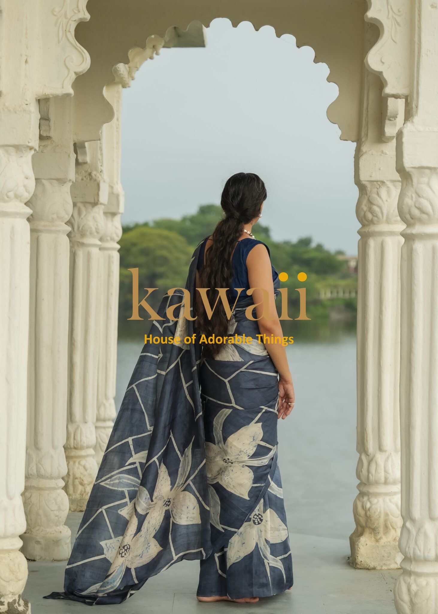 Kawaii batik saree with large floral patterns in blue and white worn by woman near lake