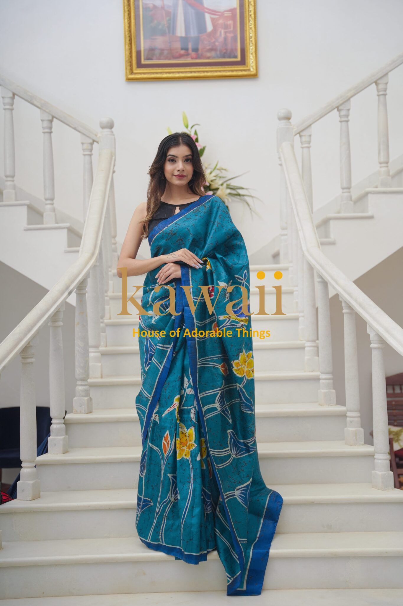 Kawaii blue batik saree with floral patterns worn by woman on white staircase